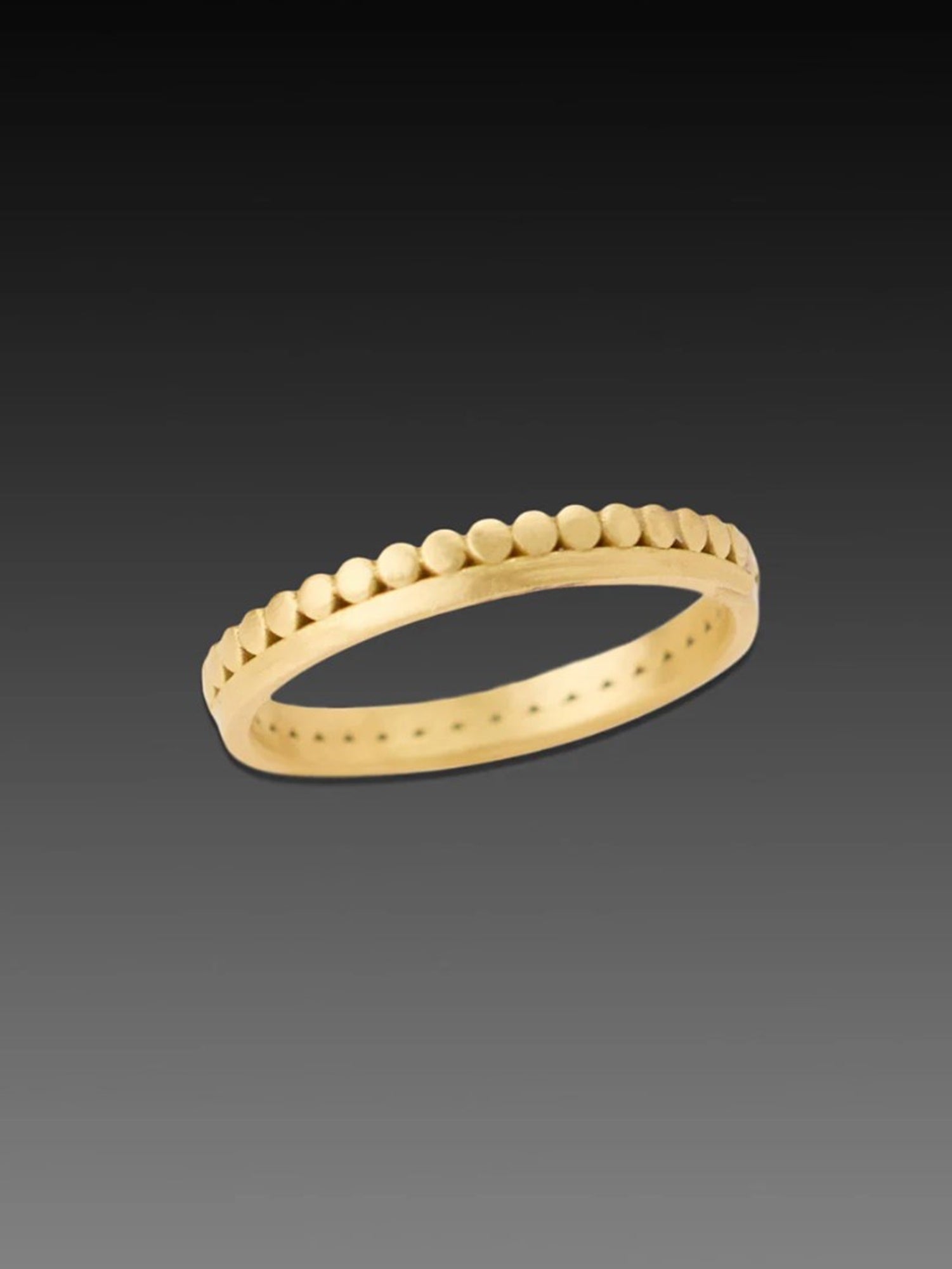 Image of American jeweler Ananda Khalsa hammered 18k matte gold side dot band with continuous side dot band above an elegant gold band