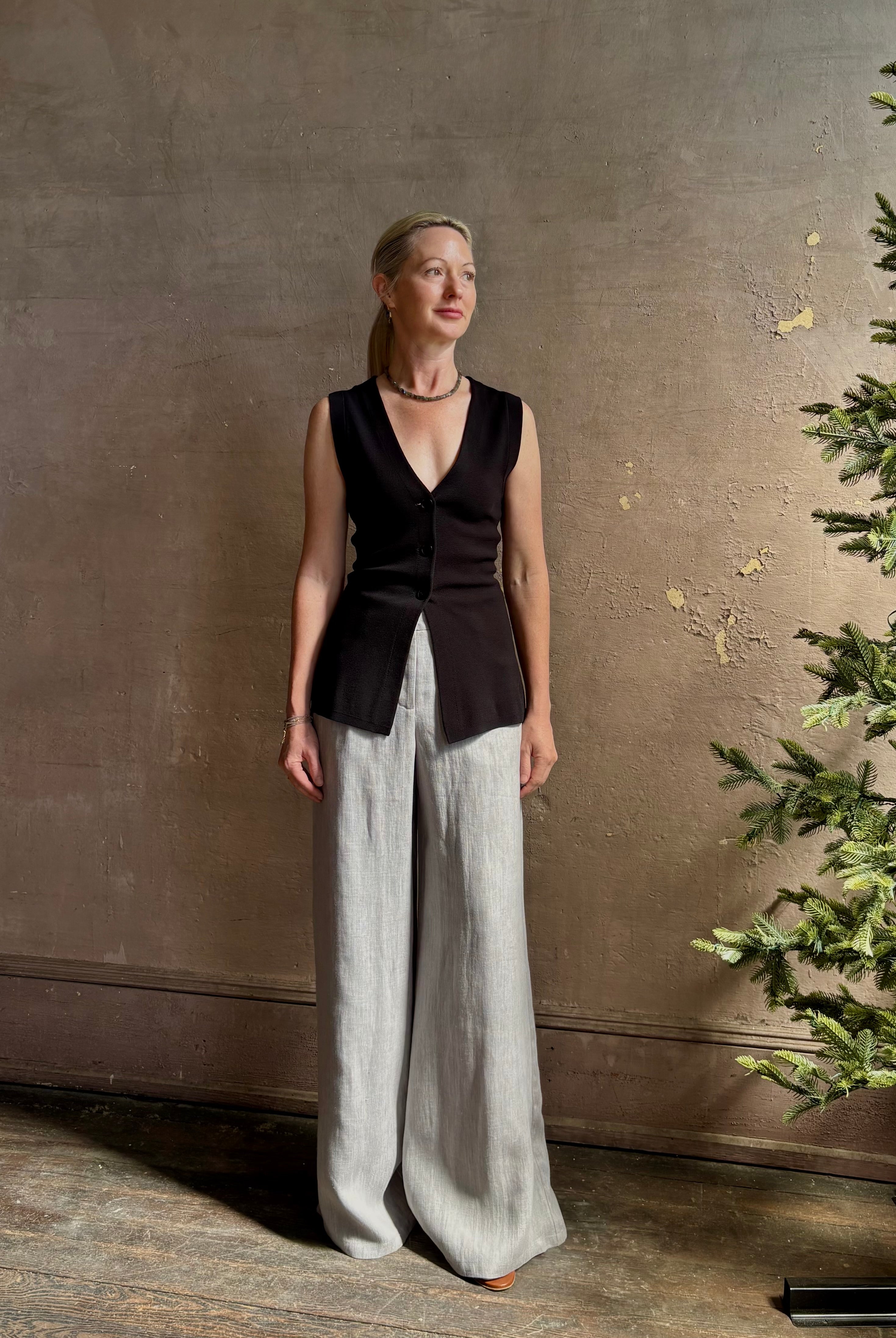 Mature woman wearing a flattering Apiece Apart Marca Knit Top in black with 3 button closure, v- neck and sleeveless