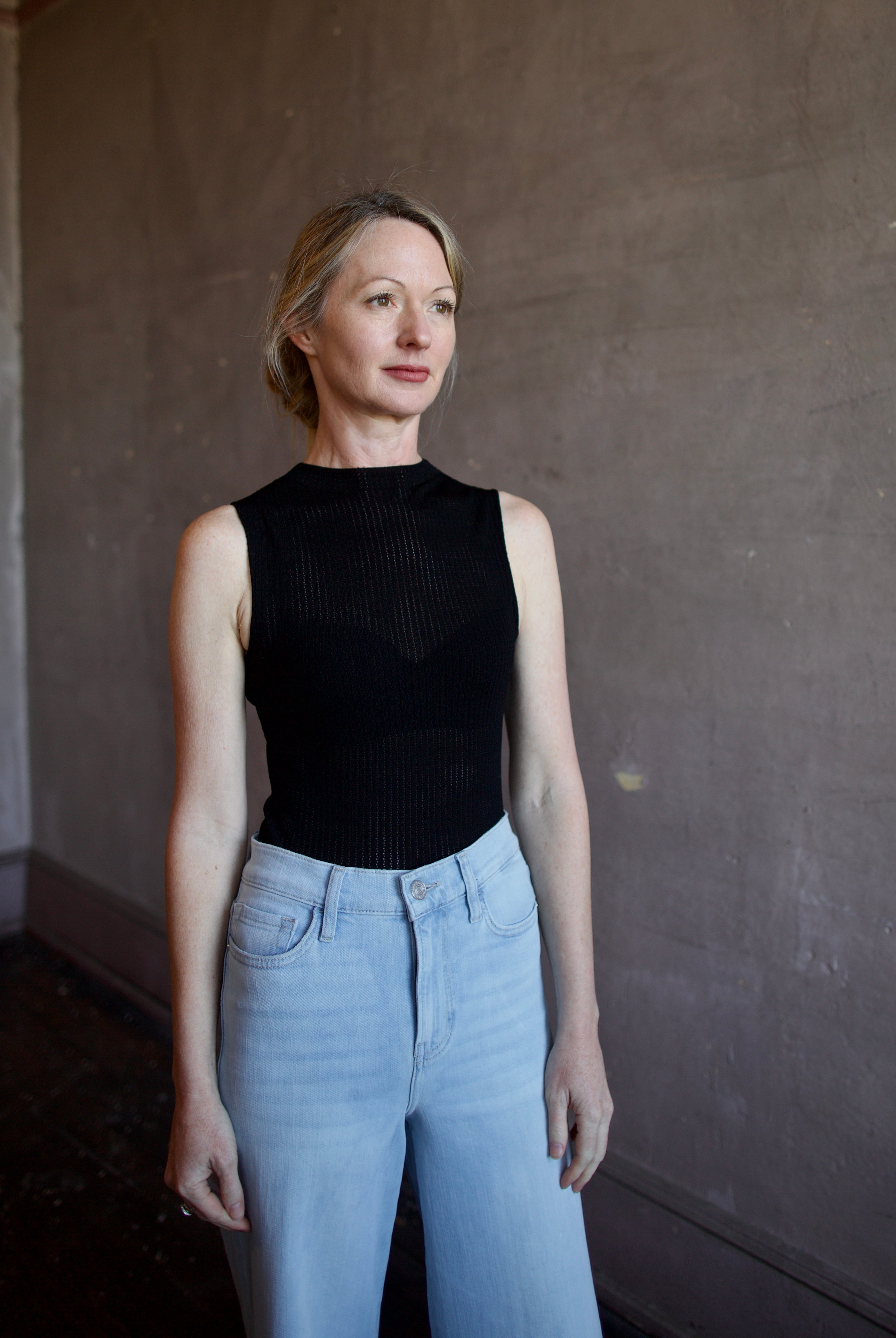 Woman wearing the Rag and Bone Molly Mock Neck Top in semi-sheer knit construction and expertly designed minimalist silhouette