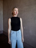 Woman wearing the Rag and Bone Molly Mock Neck Top in semi-sheer knit construction and expertly designed minimalist silhouette
