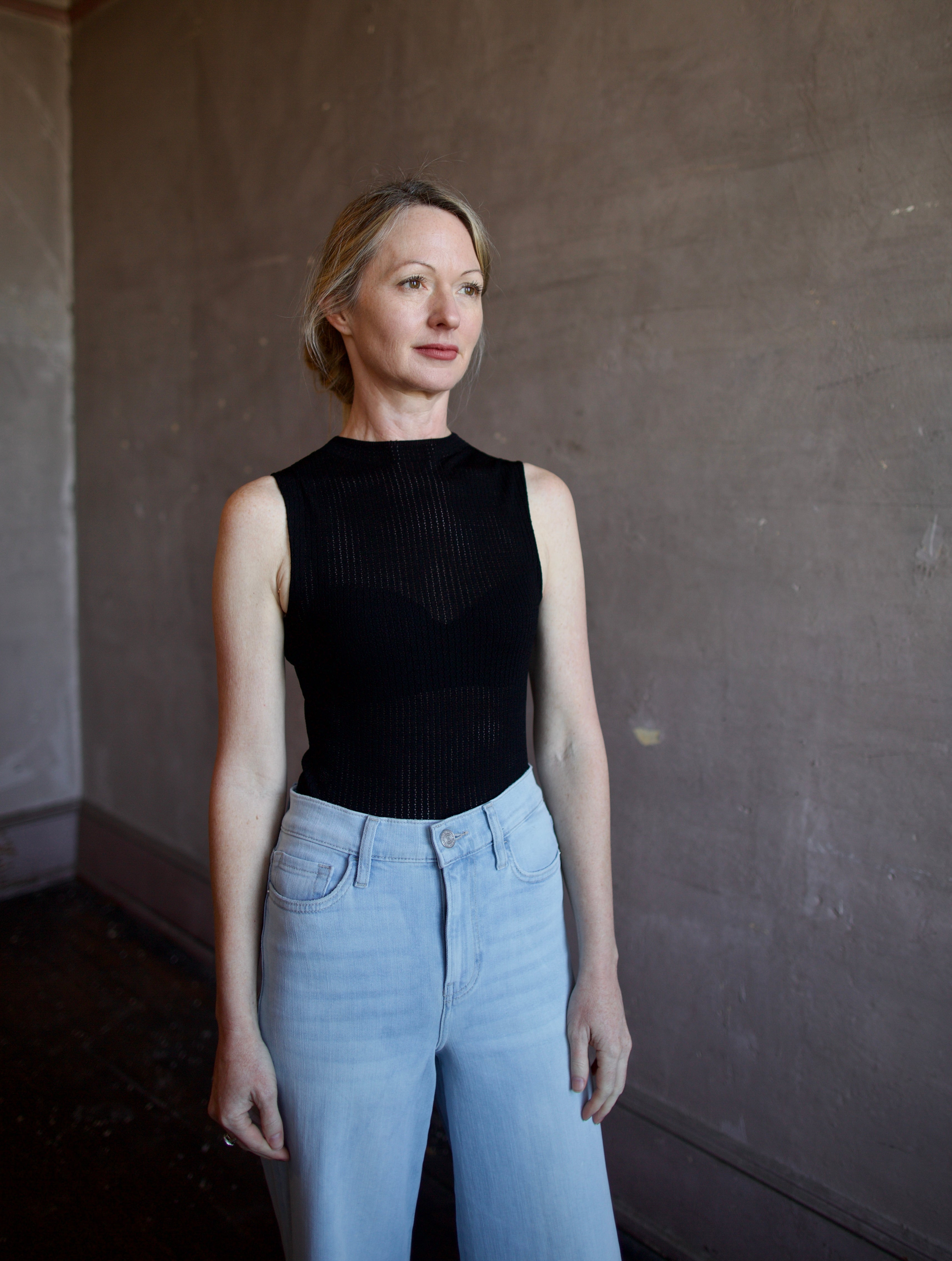 Woman wearing the Rag and Bone Molly Mock Neck Top in semi-sheer knit construction and expertly designed minimalist silhouette