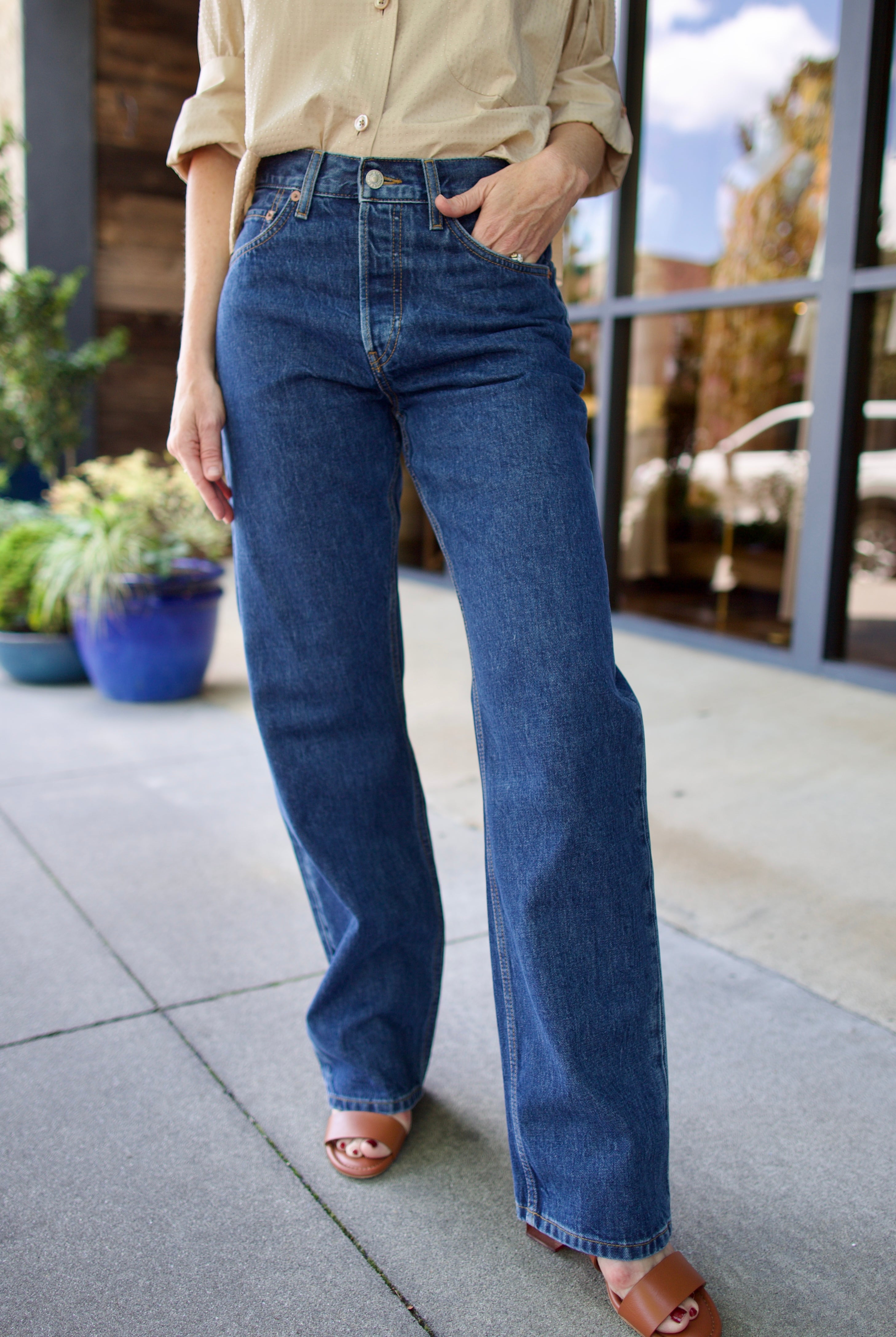 Model wearing Re/Done 90s loose blue jeans in 100% cotton rigid denim with straight leg and rusic indigo wash with no distressing