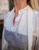 Mature woman wearing luxury brand TWP Jillian cotton-wool bustier in heather grey with bust darts and zip closure perfect for elevated layering