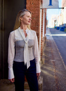Mature woman wearing luxury brand TWP Jillian cotton-wool bustier in heather grey with bust darts and zip closure perfect for elevated layering