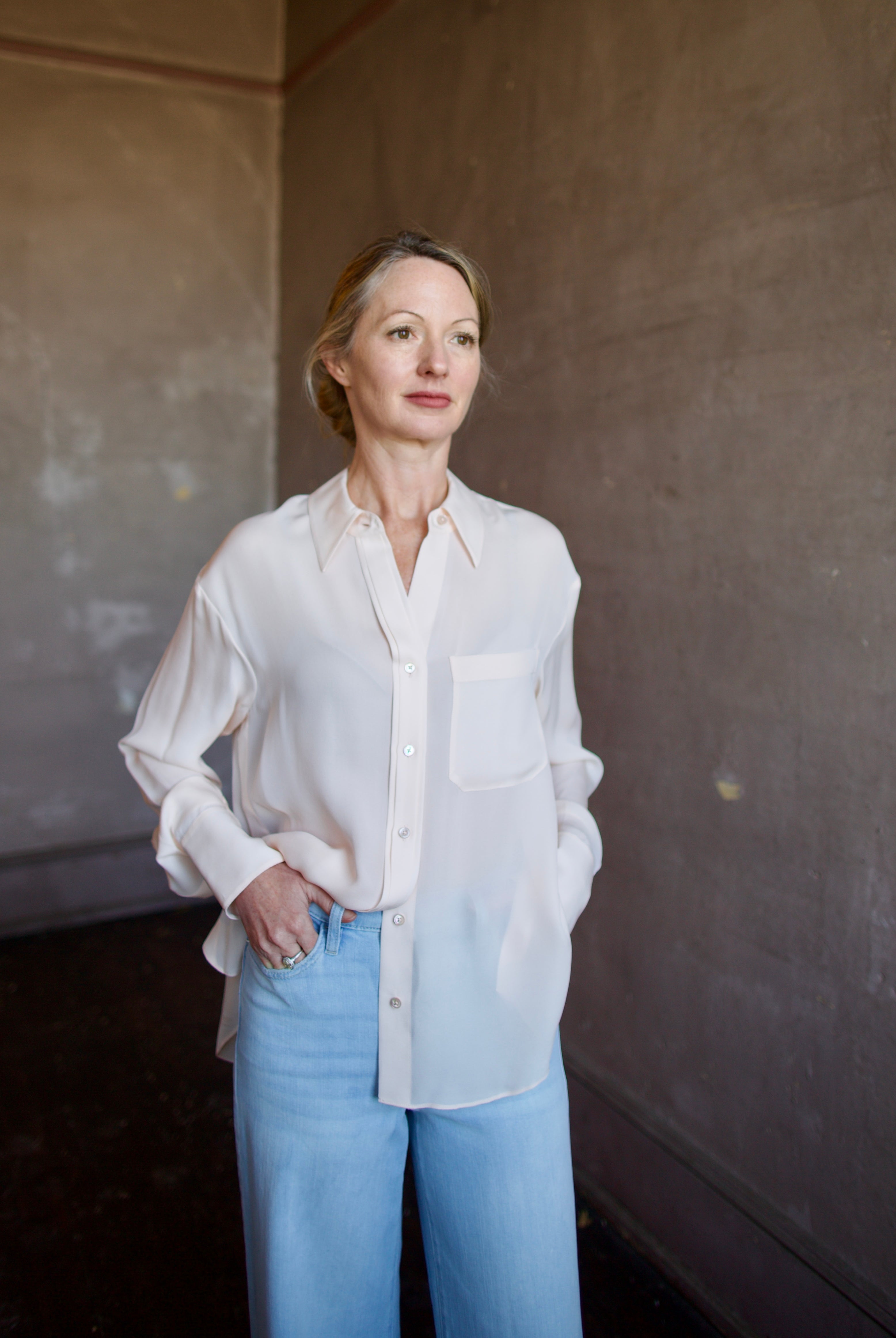Mature woman wearing luxury women's pink sheer silk Joey blouse by TWP with front pocket, delivering sophisticated elegance