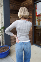 Mature woman wearing luxury brand TWP grey fine cashmere pointelle knit crewneck top perfect lightweight layering in cool weather