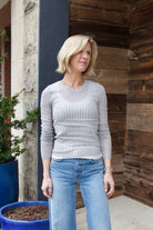 Mature woman wearing luxury brand TWP grey fine cashmere pointelle knit crewneck top perfect lightweight layering in cool weather