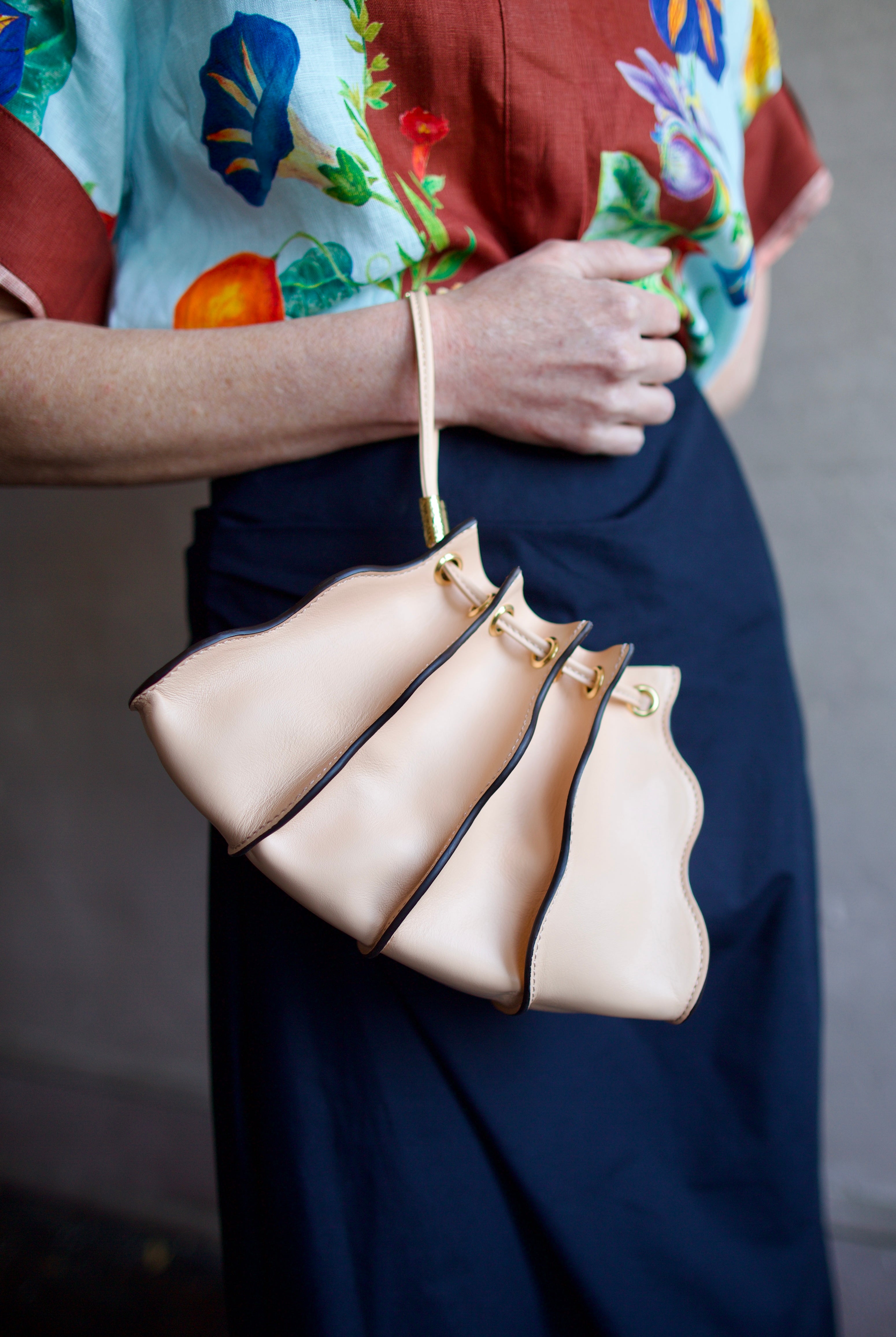 Close up image of a woman wearing the Ulla Johnson Adria Pleated Wave Pochette