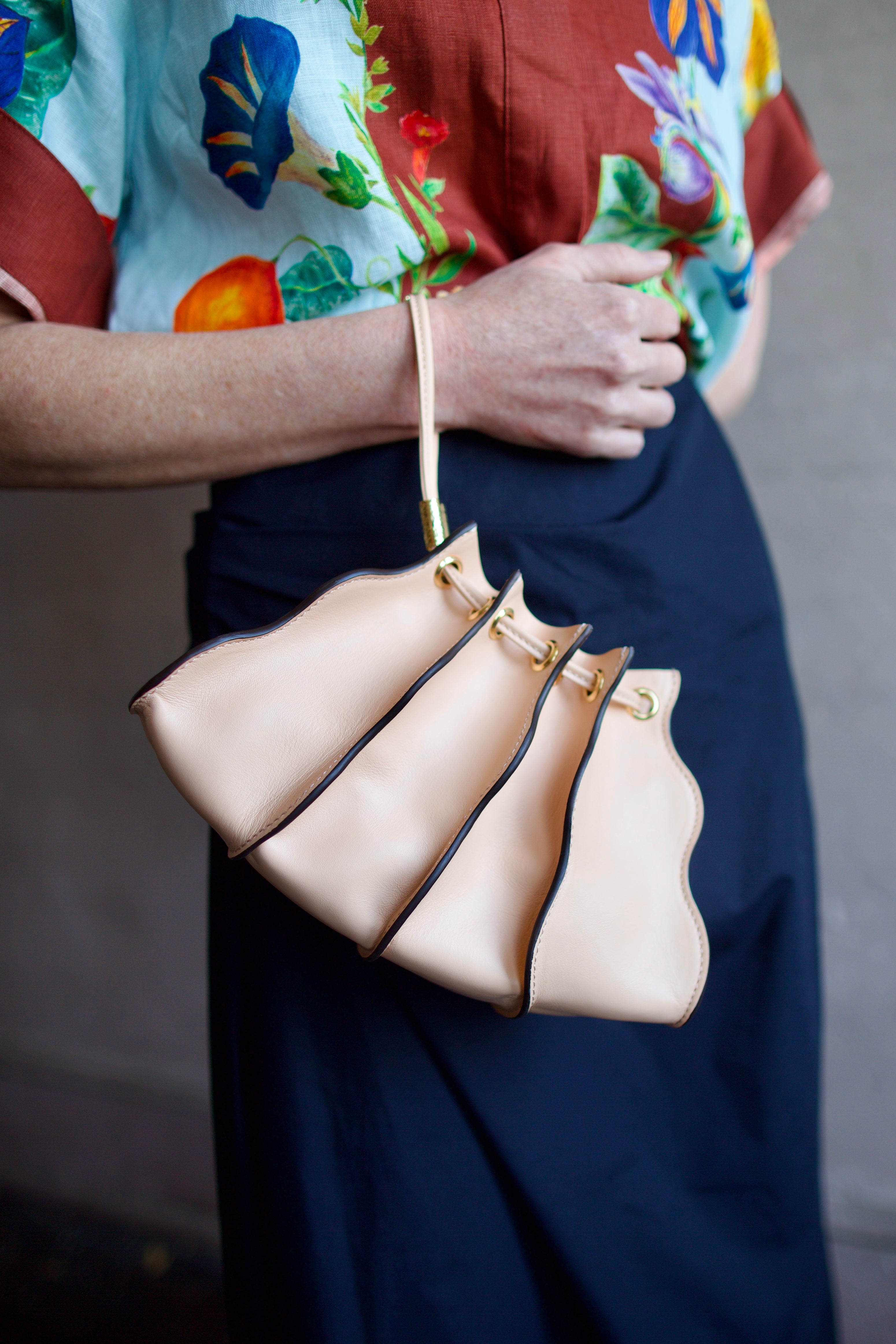 Close up image of a woman wearing the Ulla Johnson Adria Pleated Wave Pochette