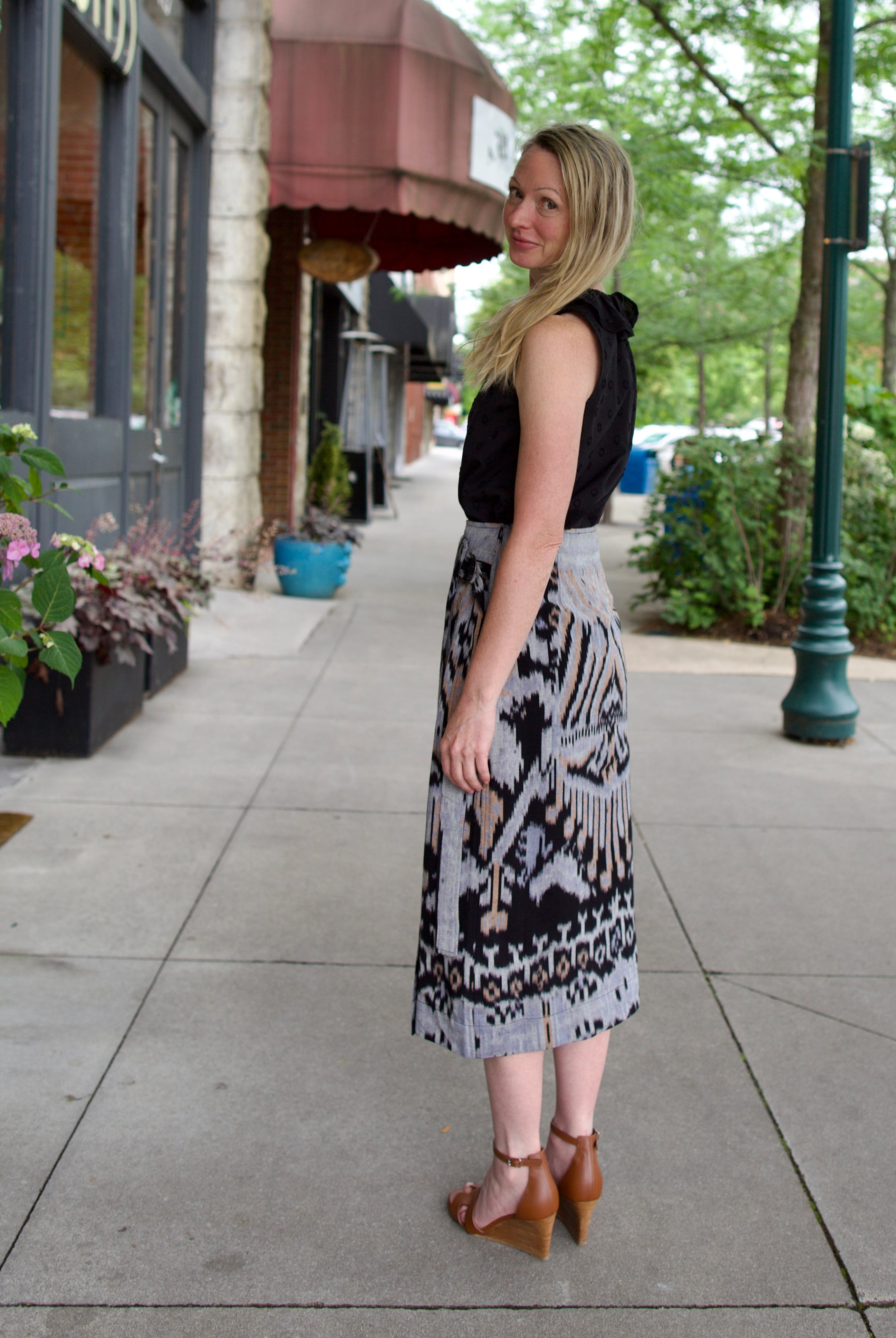 Model wearing luxury designer Ulla Johnson lightweight cotton Mila Pencil wrap Skirt in ikat black and purple colorway with pocket