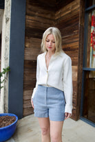 Woman wearing Vanessa Bruno Elisam luxury blue linen cotton shorts with a tailored fit and pinstripe pattern in expert Parisian craftsmanship
