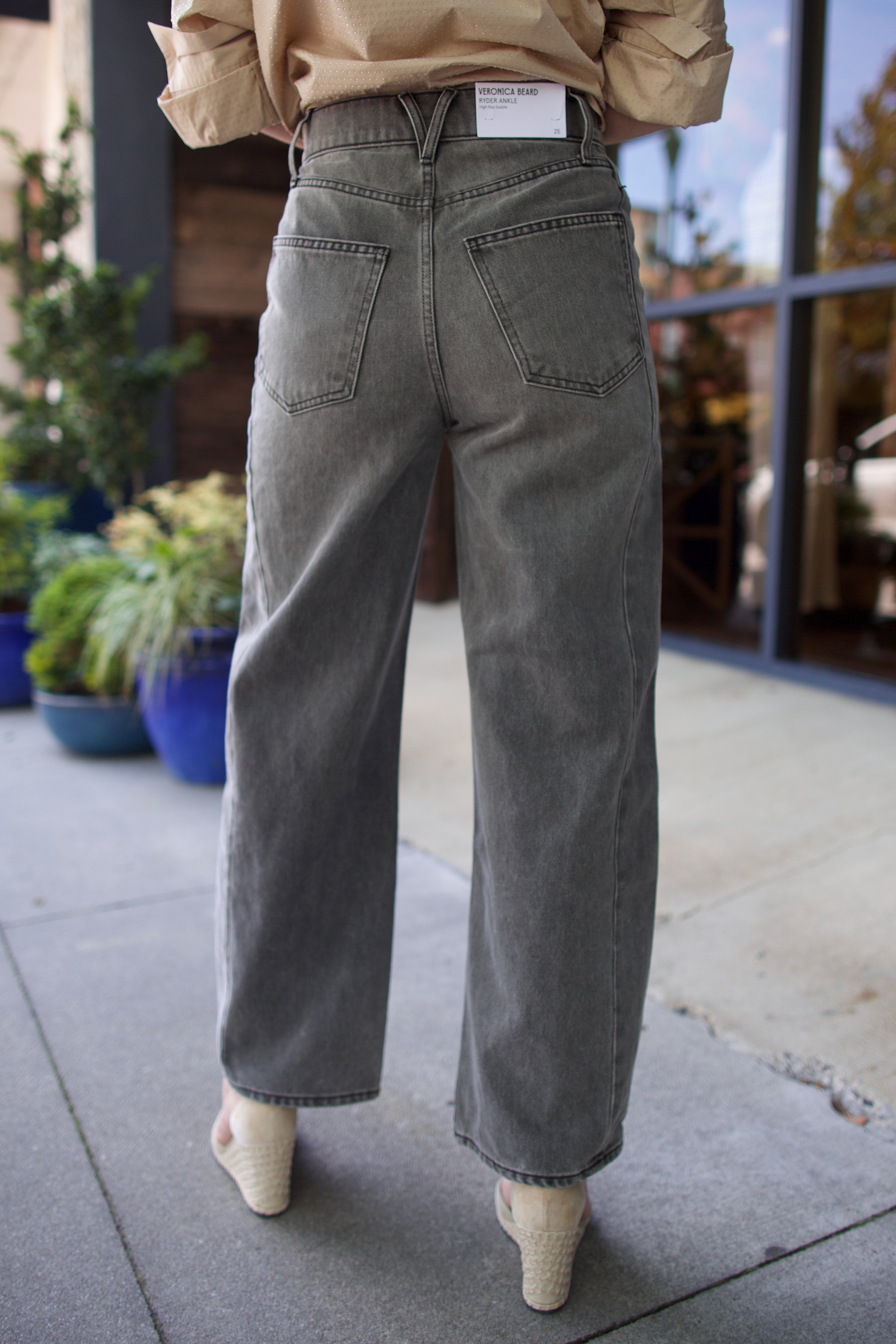 Mature model wearing designer brand Veronica Beard high rise Ryder grey barrel denim fabricated with rigid cotton