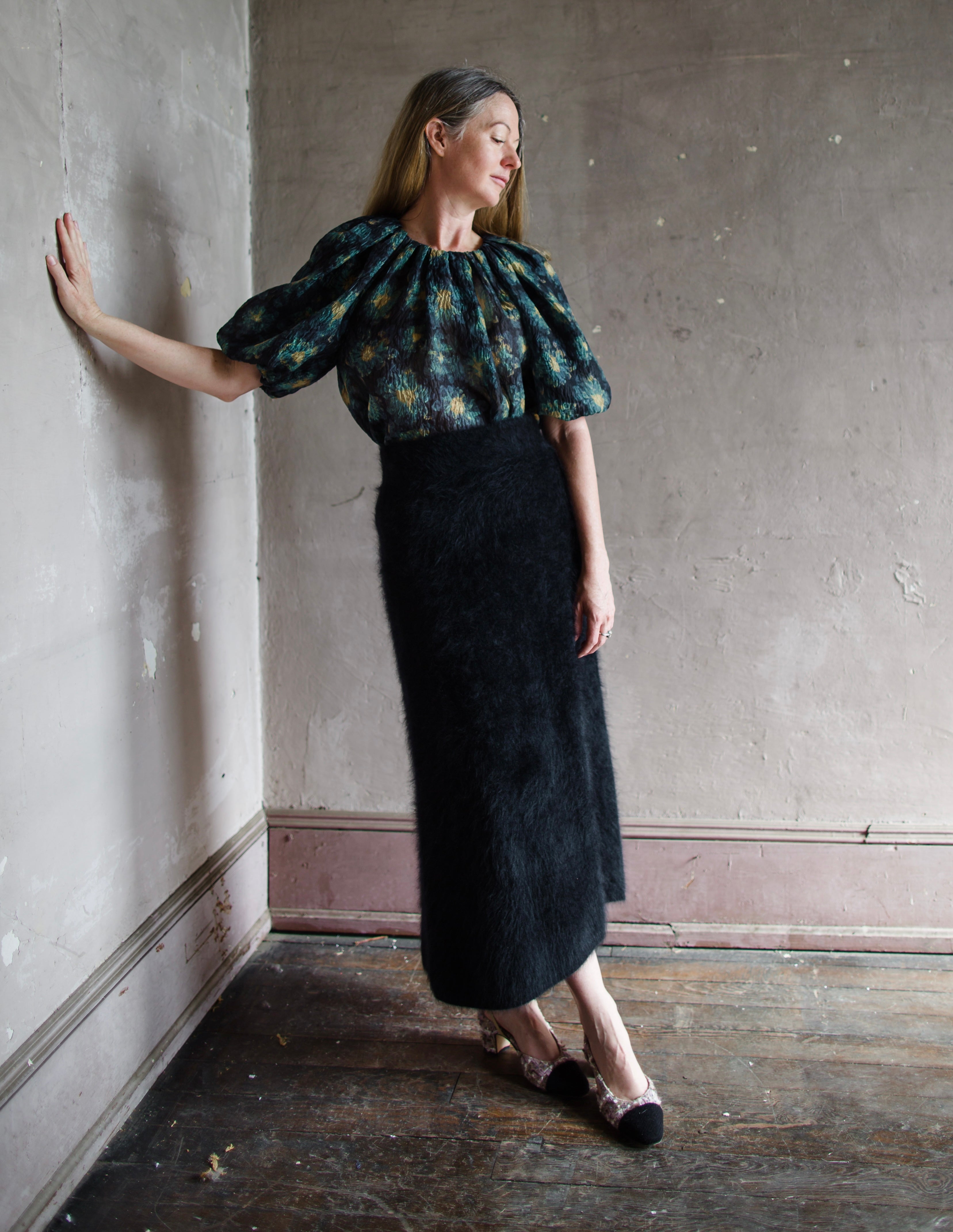 Image featuring a woman wearing the Asta skirt by Lisa Yang with a high rise and a-line shape in black brushed cashmere texture.