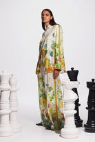 Image featuring a woman wearing the silk twill Constance top by Alemais with a button front and a split down the center back with ties in an allover floral print.