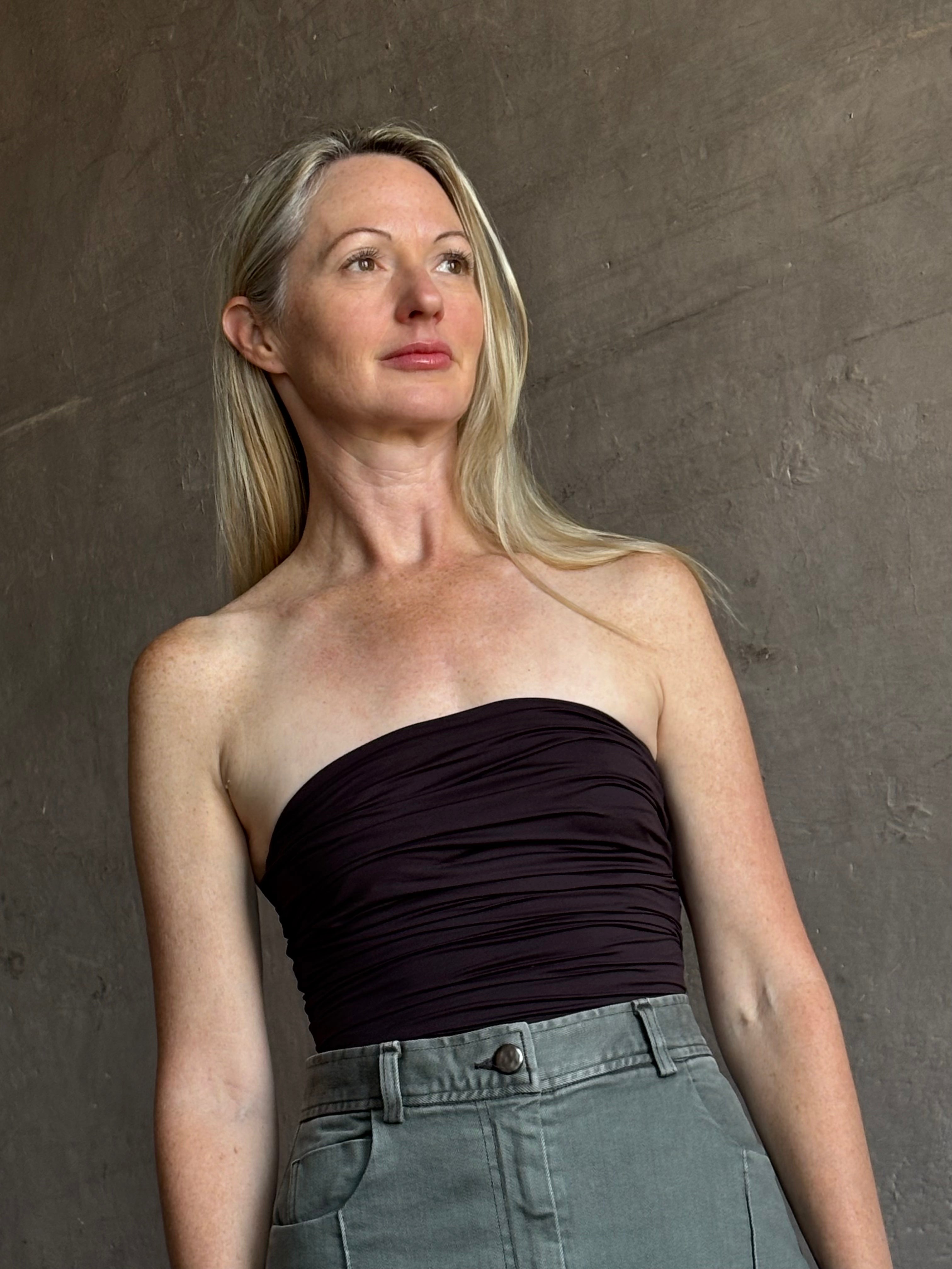 Image of mature woman wearing AGOLDE Gwyneth Bodysuit in chocolate brown with premium stretch for timeless versatile styling 