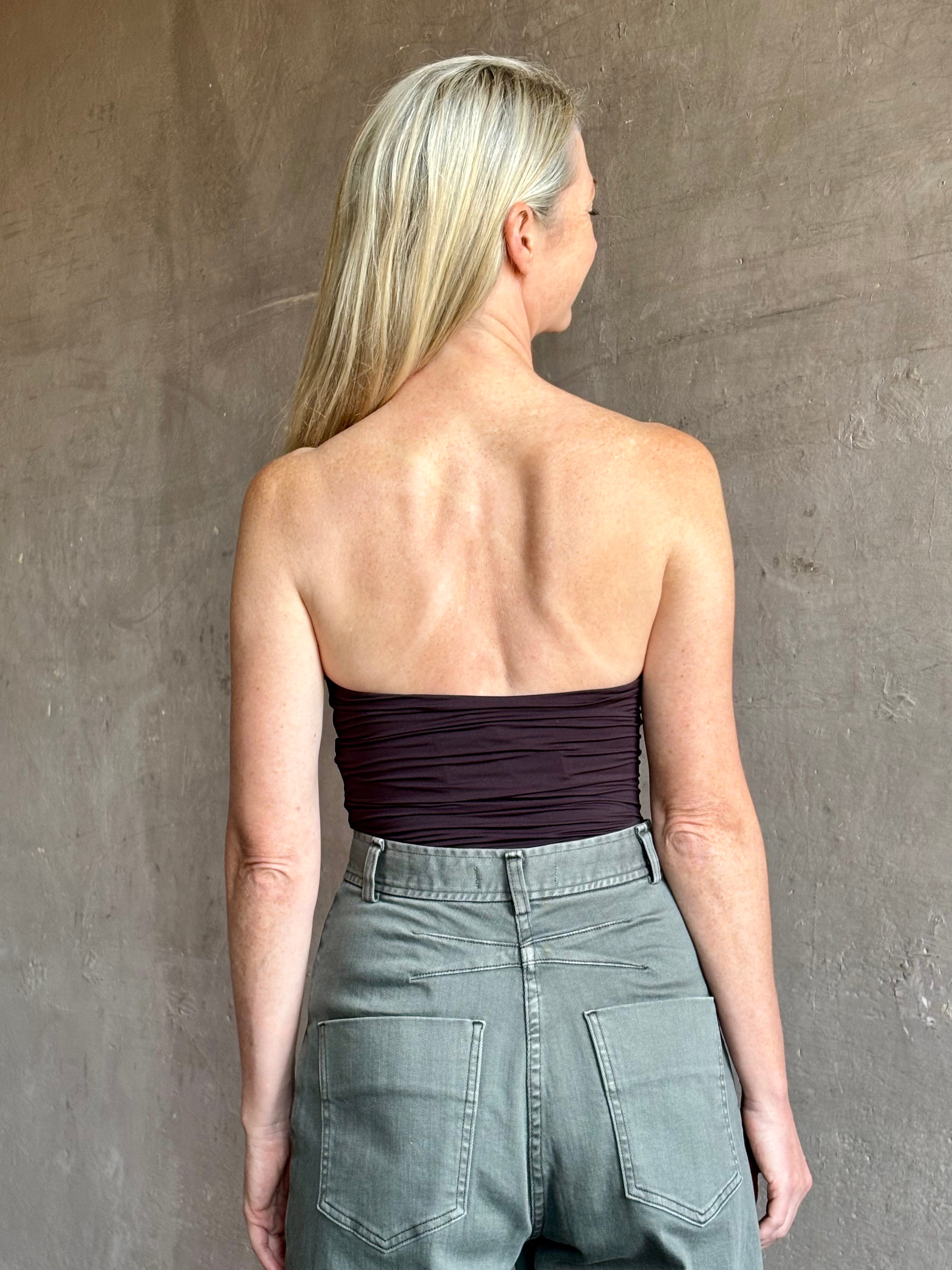 Image of mature woman wearing AGOLDE Gwyneth Bodysuit in chocolate brown with premium stretch for timeless versatile styling 