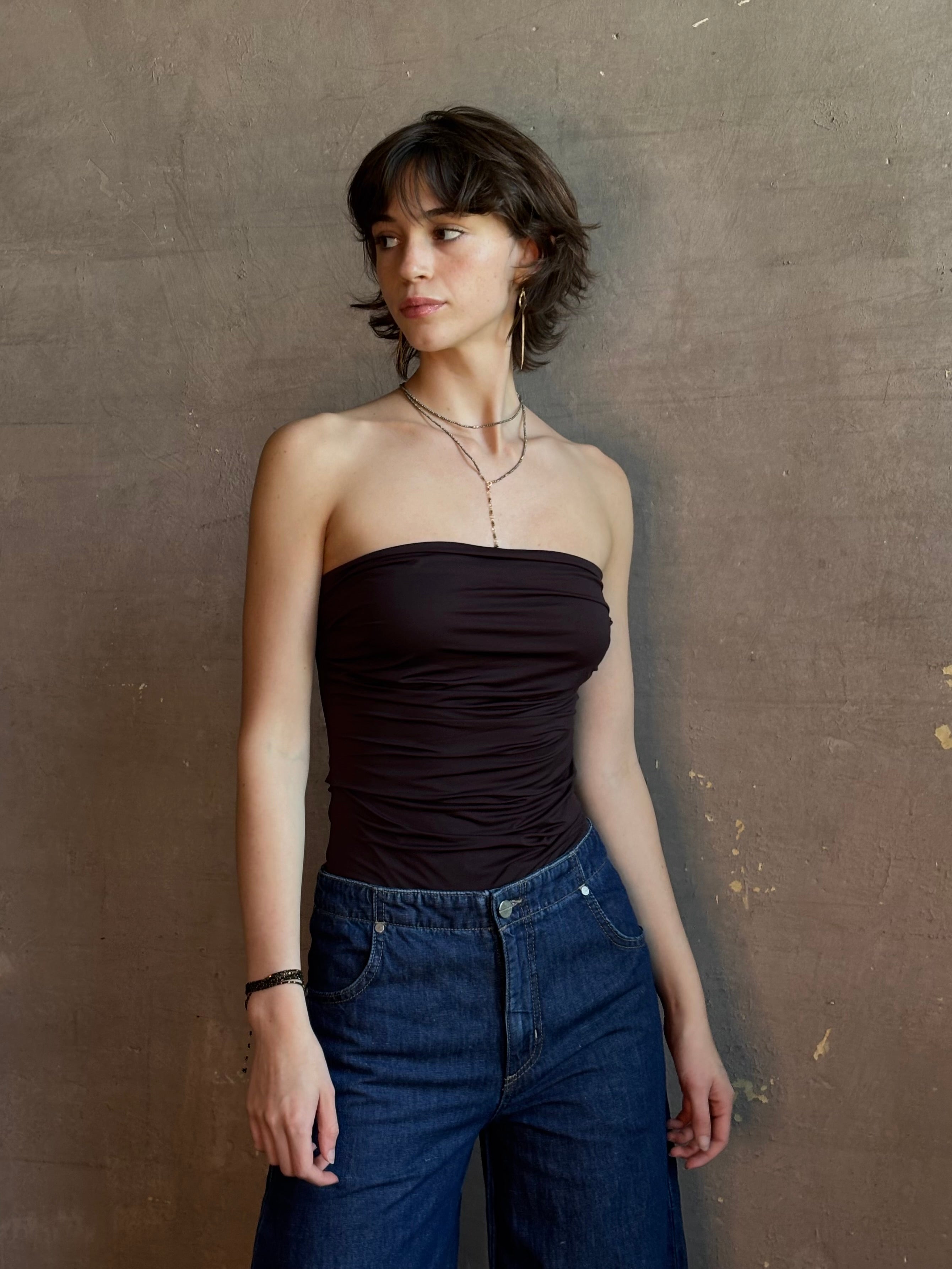 Woman wearing AGOLDE Gwyneth Bodysuit in chocolate brown with premium stretch for timeless versatile styling with gathered fabric body that is very forgiving while form fitted