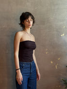 Woman wearing AGOLDE Gwyneth Bodysuit in chocolate brown with premium stretch for timeless versatile styling with gathered fabric body that is very forgiving while form fitted