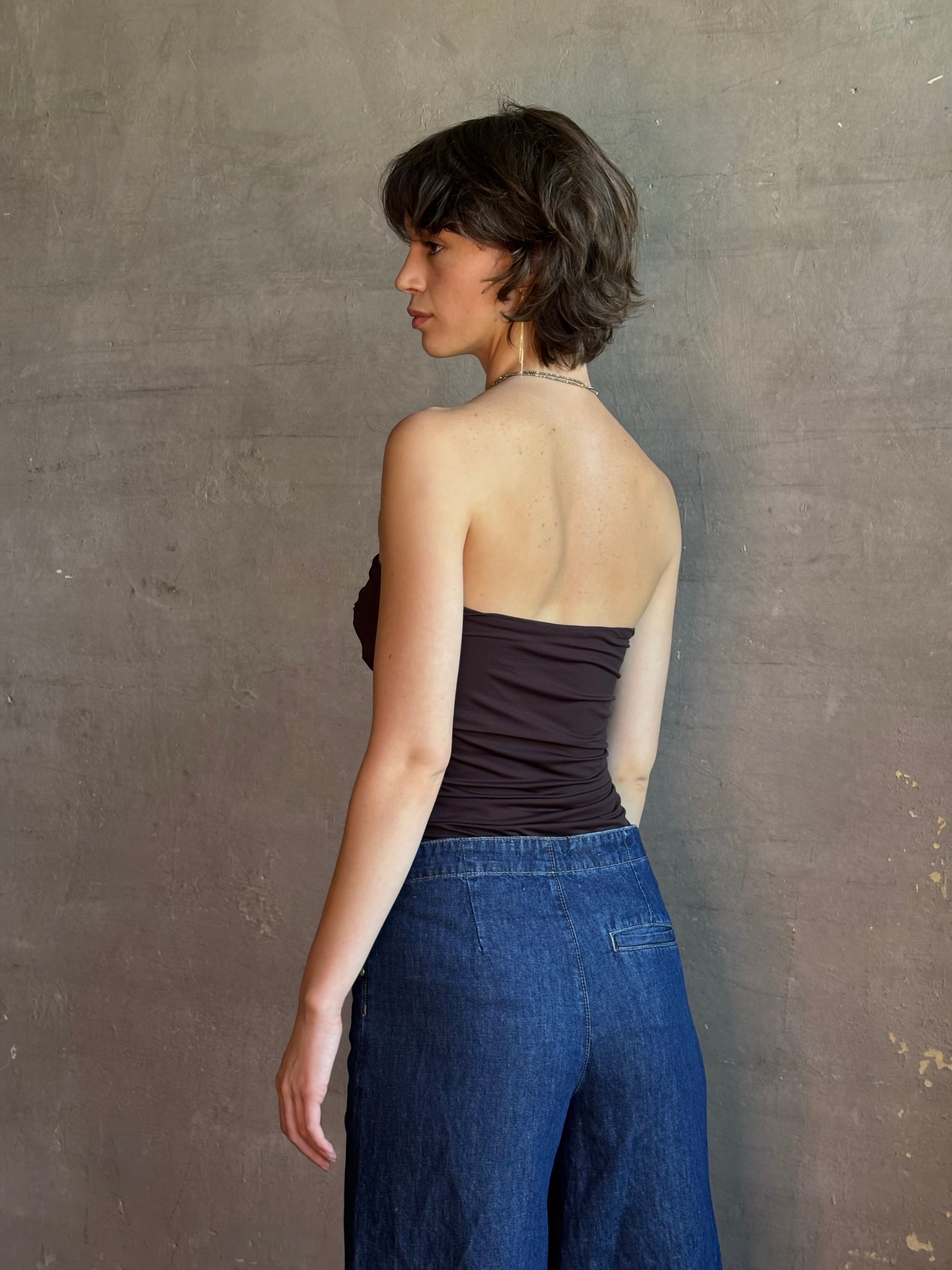 Woman wearing AGOLDE Gwyneth Bodysuit in chocolate brown with premium stretch for timeless versatile styling with gathered fabric body that is very forgiving while form fitted