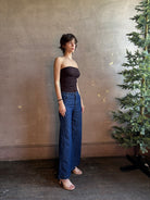 Woman wearing AGOLDE Gwyneth Bodysuit in chocolate brown with premium stretch for timeless versatile styling with gathered fabric body that is very forgiving while form fitted