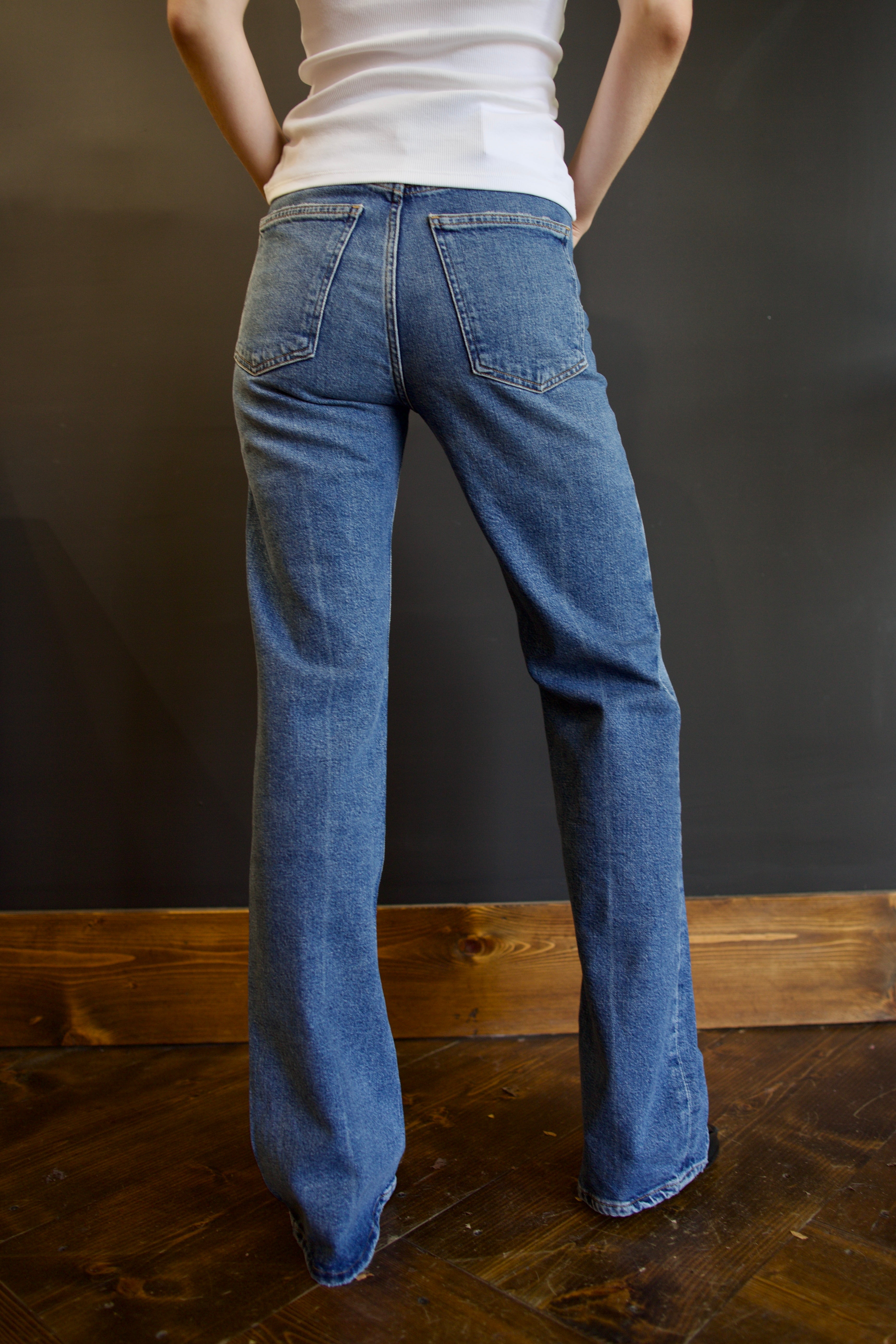 Model wearing Agolde mid-rise kick boot comfort denim in curve wash with generous inseam