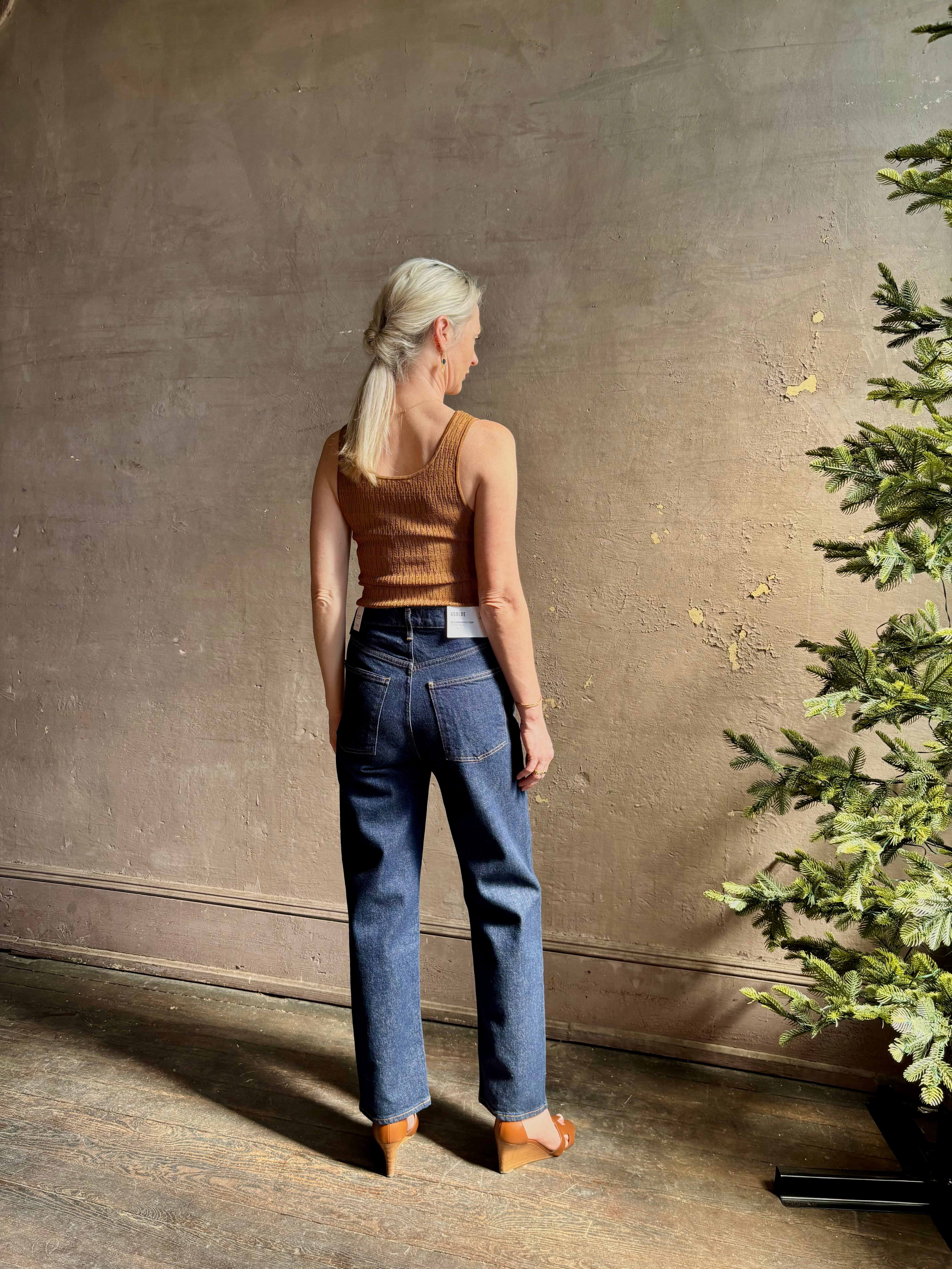 Mature woman wearing Agolde 90's Pinch Waist Crop with regenerative cotton zip closuredark wash