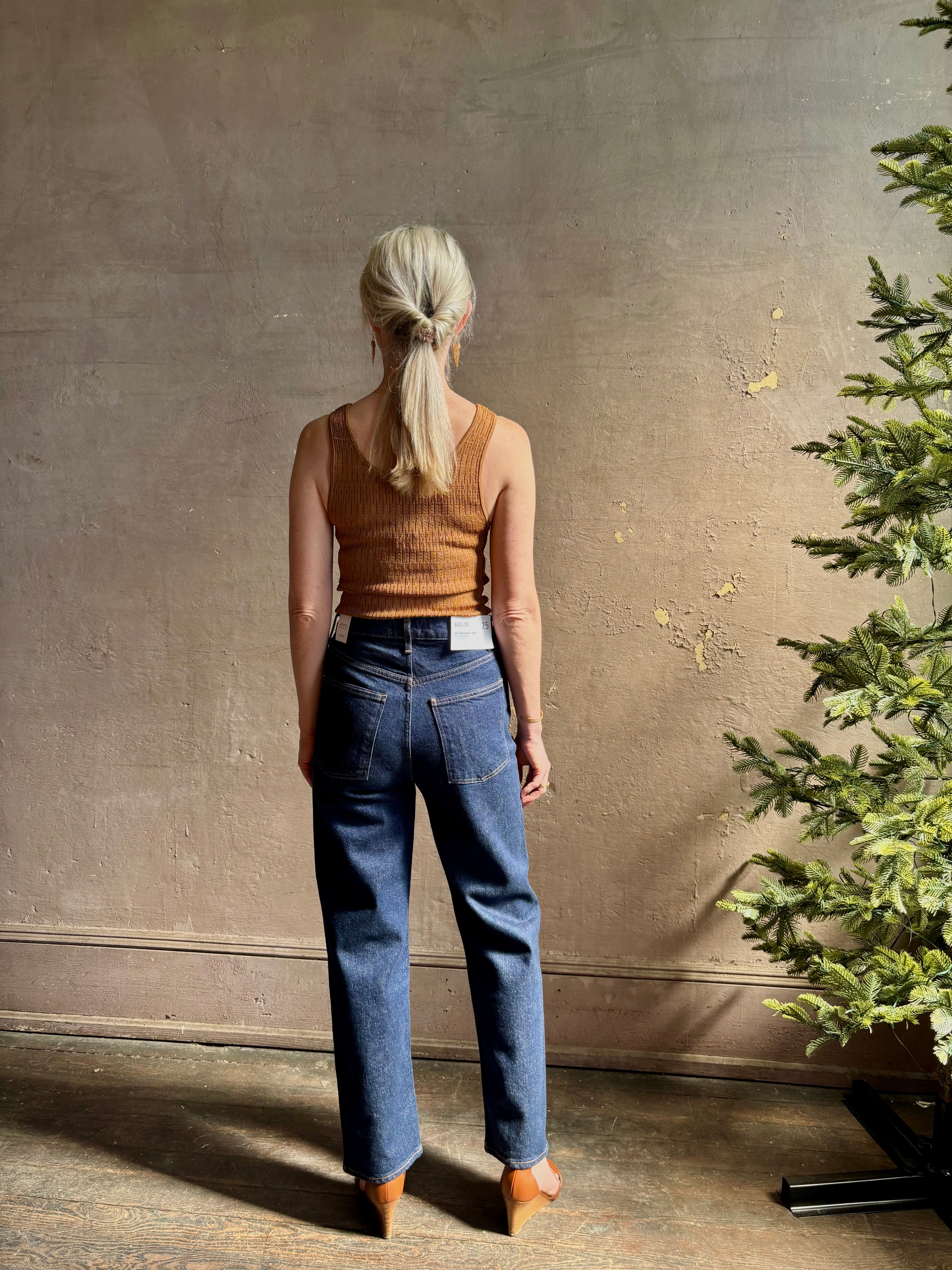 Mature woman wearing Agolde 90's Pinch Waist Crop with regenerative cotton zip closure back pockets