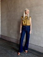 Image of mature woman wearing premium LA regenerative denim AGOLDE Kick Boot Ankle in Reissue dark wash with no distressing and a finished hem