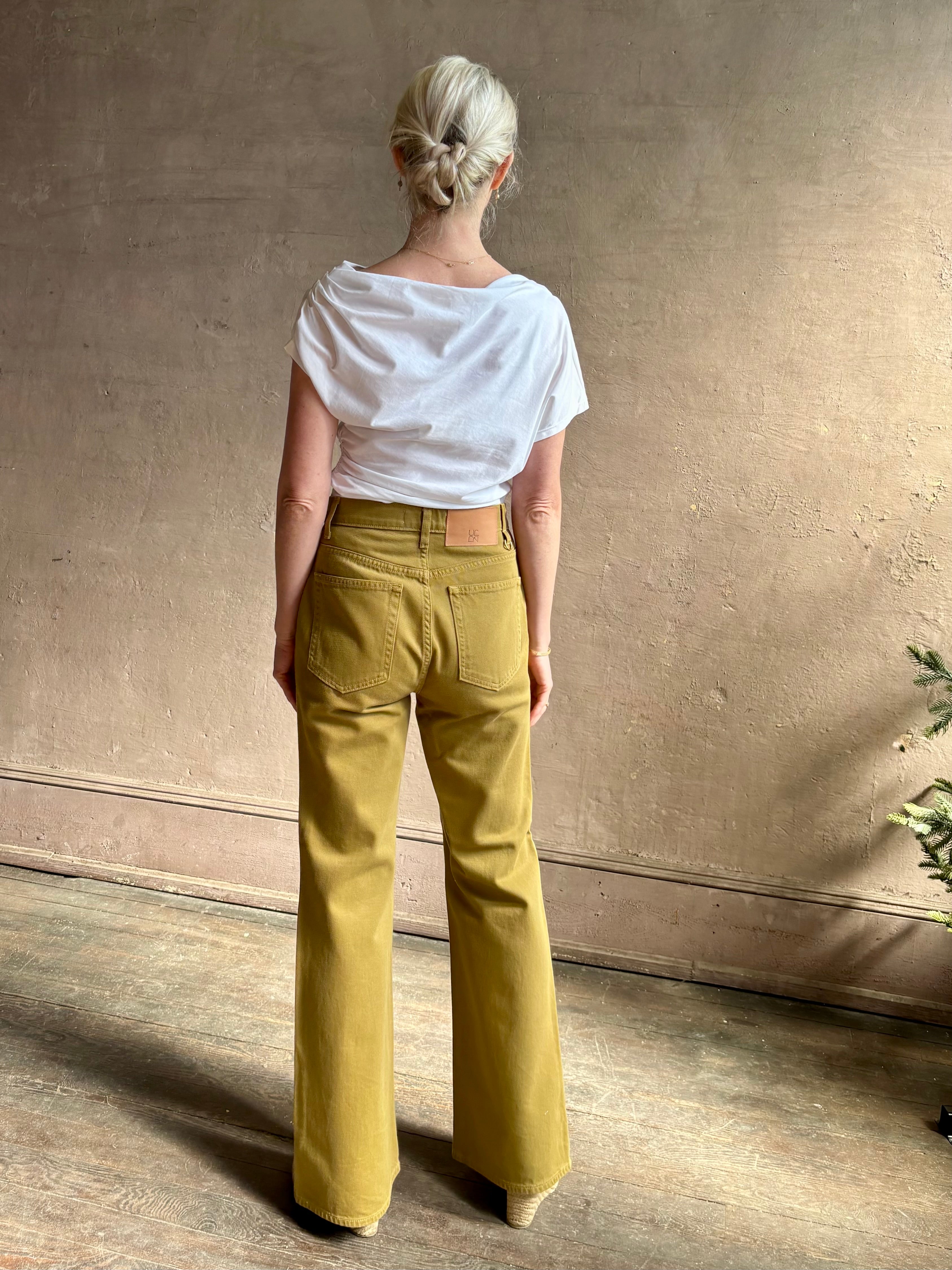 Mature woman wearing ALC Alice cotton t-shirt with ruched side and shoulder detail that can be worn asymmetrically in bright white 