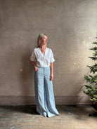 Mature woman wearing The A.L.C. Jordan Top in White Long sleeve blouse boasts premium cotton blend with v-neck and tab to roll sleeves up to a half sleeve
