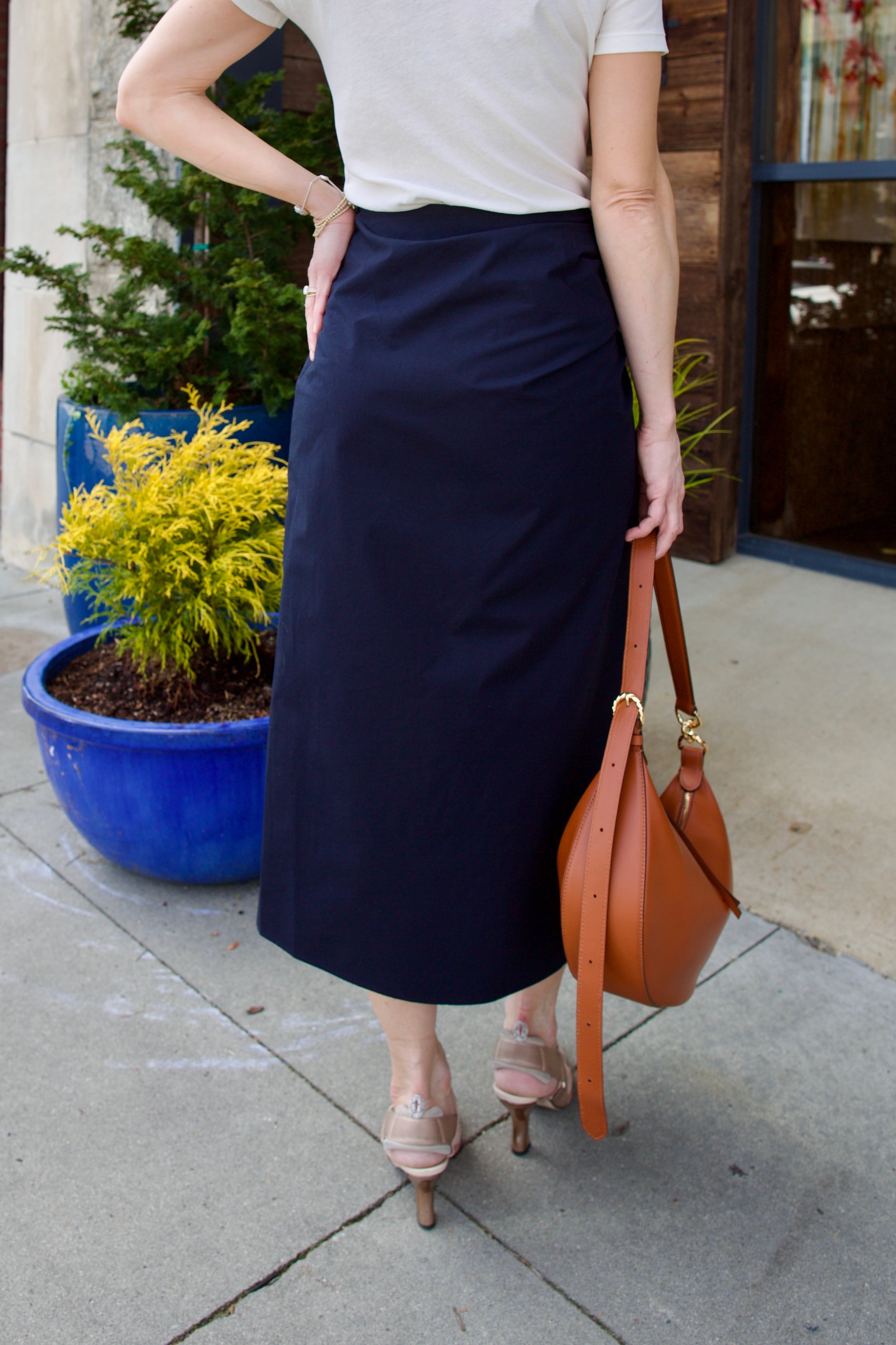 Image of woman wearing luxury women's cotton ALC Tessa skirt with ruched waistband with asymmetrical hem line