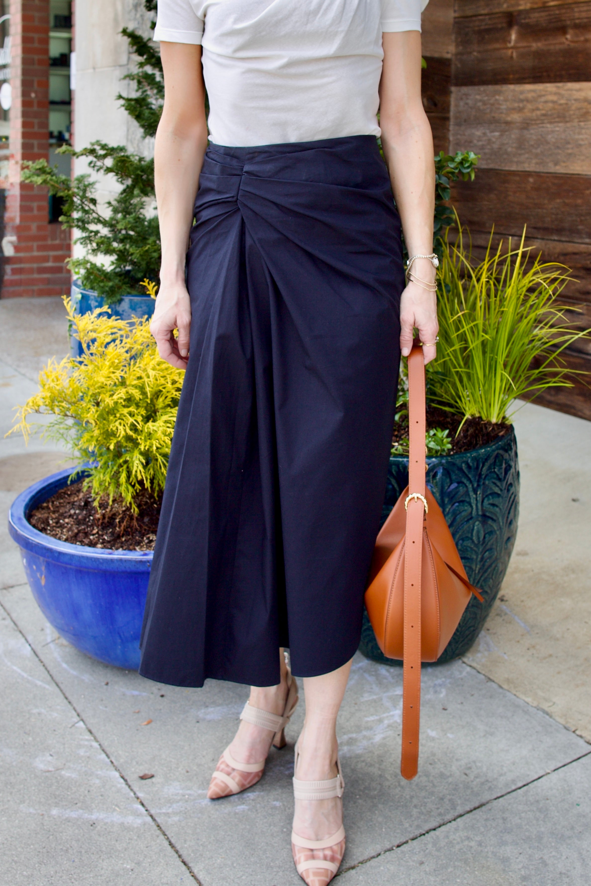 Image of woman wearing luxury women's cotton ALC Tessa skirt with ruched waistband with asymmetrical hem line