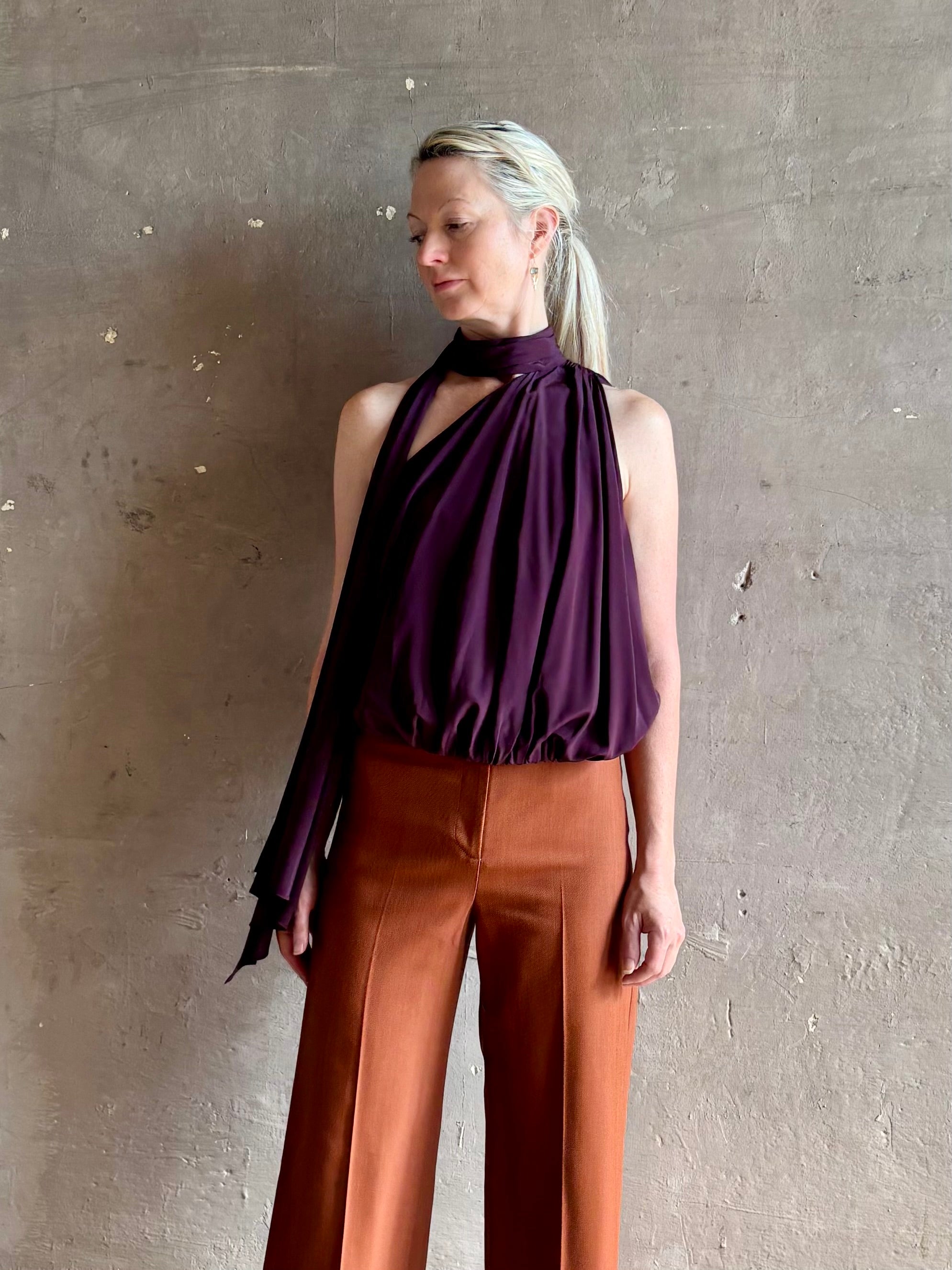 Mature model wearing ALC silk celeste top with one shoulder halter neck attached scarf sophisticated draping
