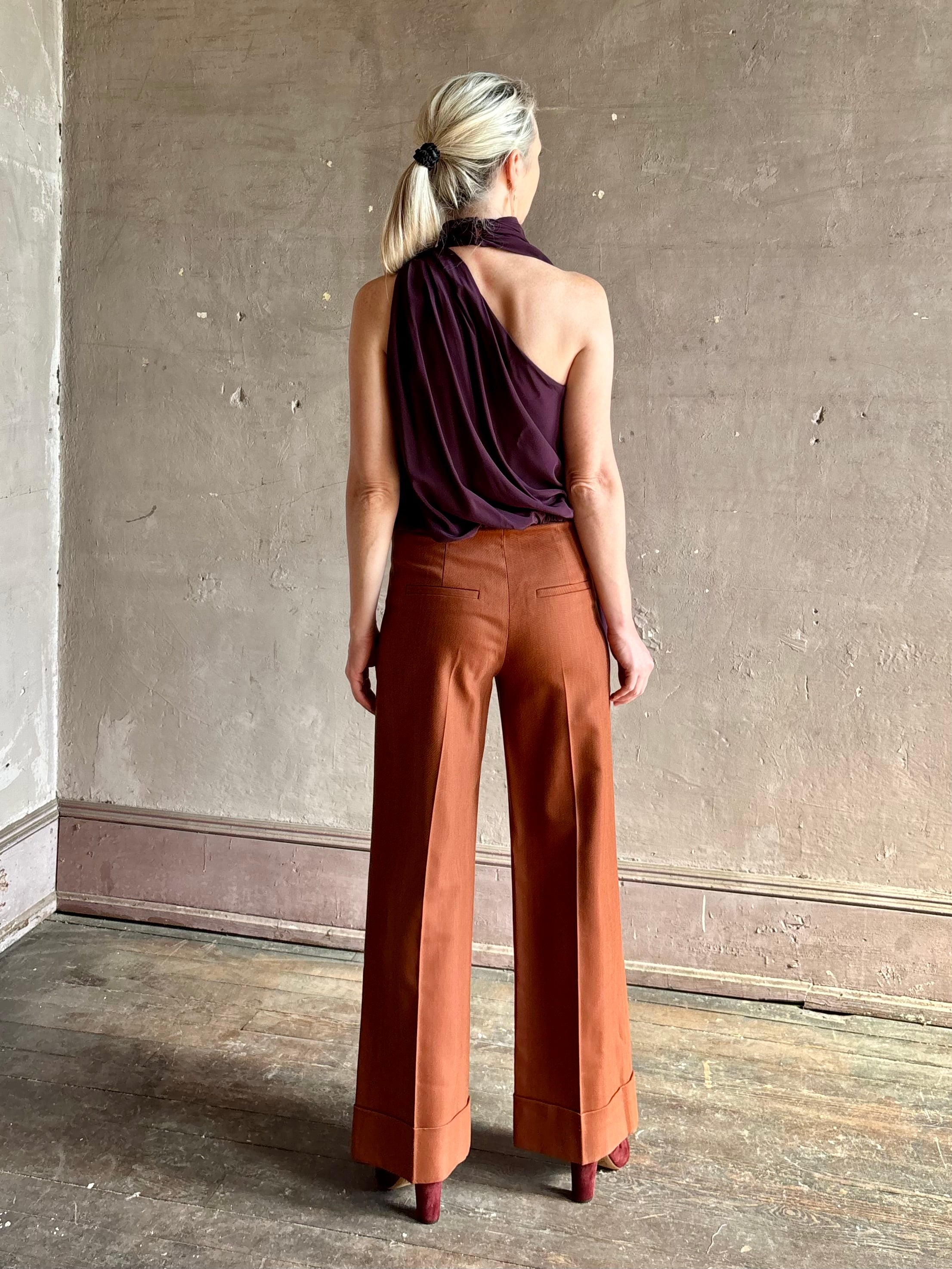 Mature model wearing ALC silk celeste deep purple top with one shoulder bubble hemline fluid draping