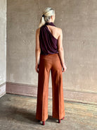 Mature model wearing ALC silk celeste deep purple top with one shoulder bubble hemline fluid draping