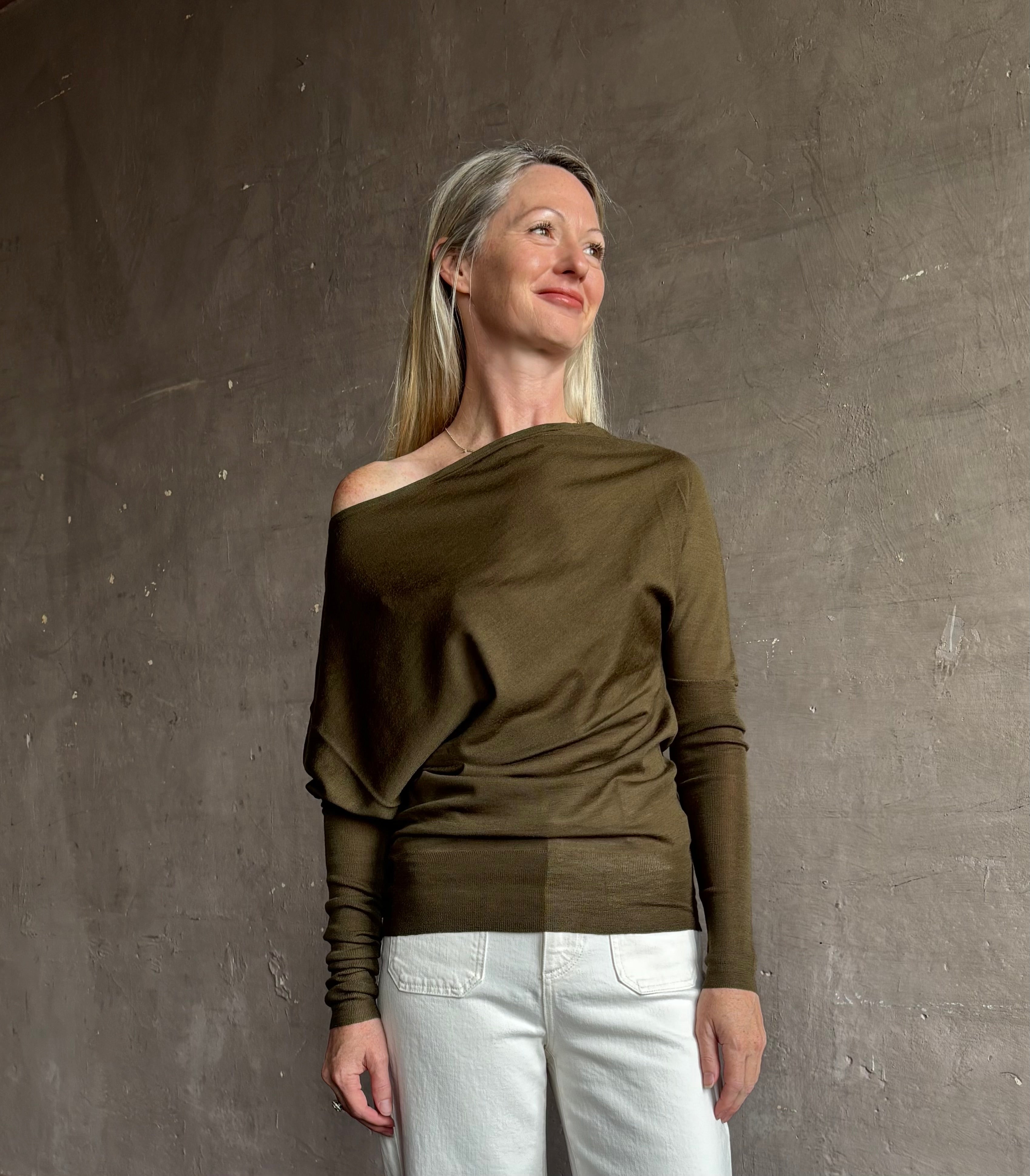 Image of a mature woman wearing contemporary fashion designer ALC Liv Top in an symmetric neckline with off-shoulder draping in army green