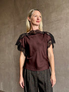 Image of mature woman wearing ALC Luna top in premium chocolate brown viscose blouse with a boat neck short sleeve and refined black lace trim