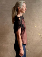 Image of mature woman wearing ALC Luna top in premium chocolate brown viscose blouse with a boat neck short sleeve and refined black lace trim