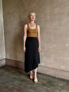 Mature woman wearing ALC Tracy skirt in black wool with asymetrical hemline and pleating