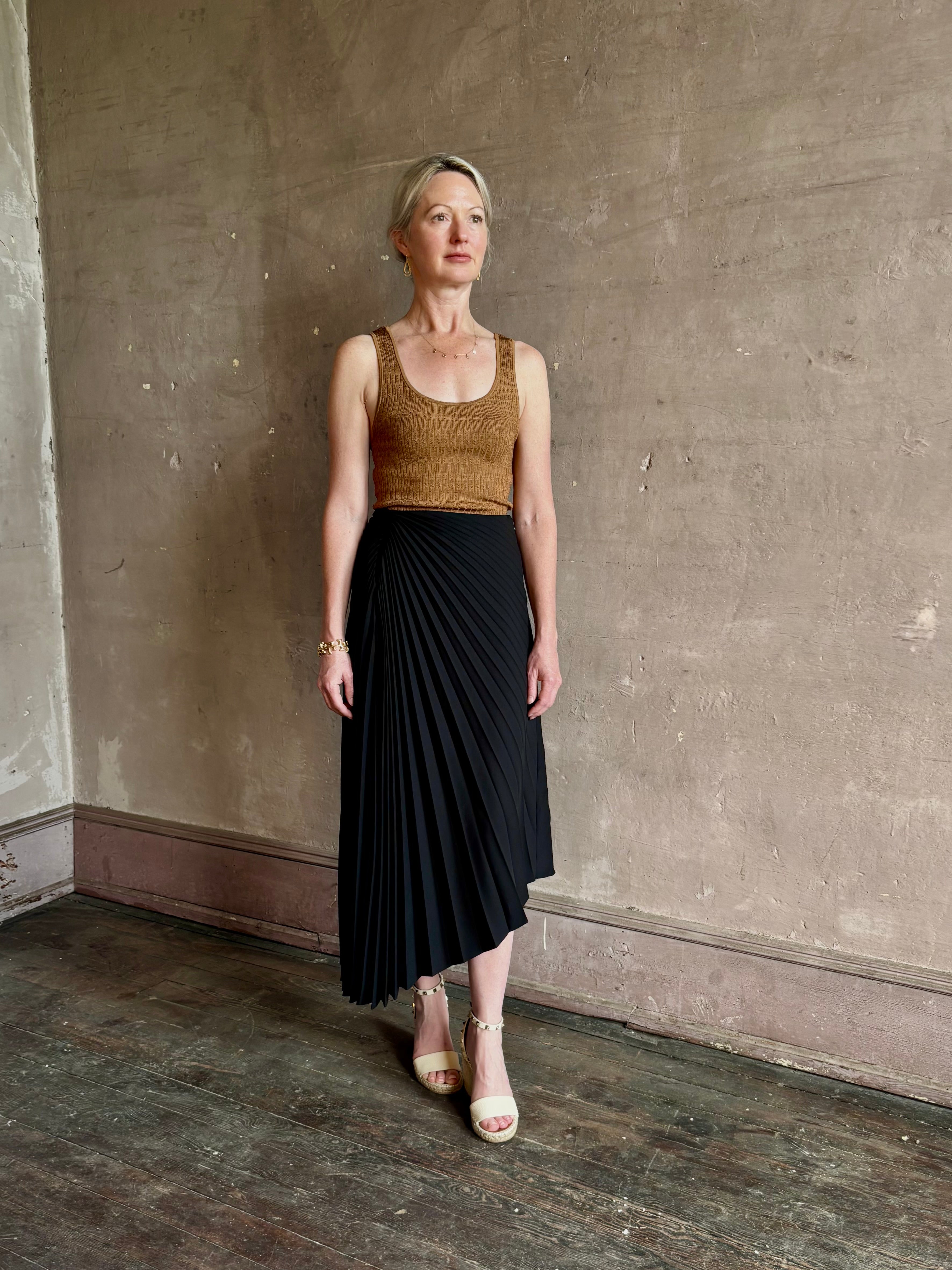 Mature woman wearing ALC Tracy skirt in black wool with asymetrical hemline and pleating