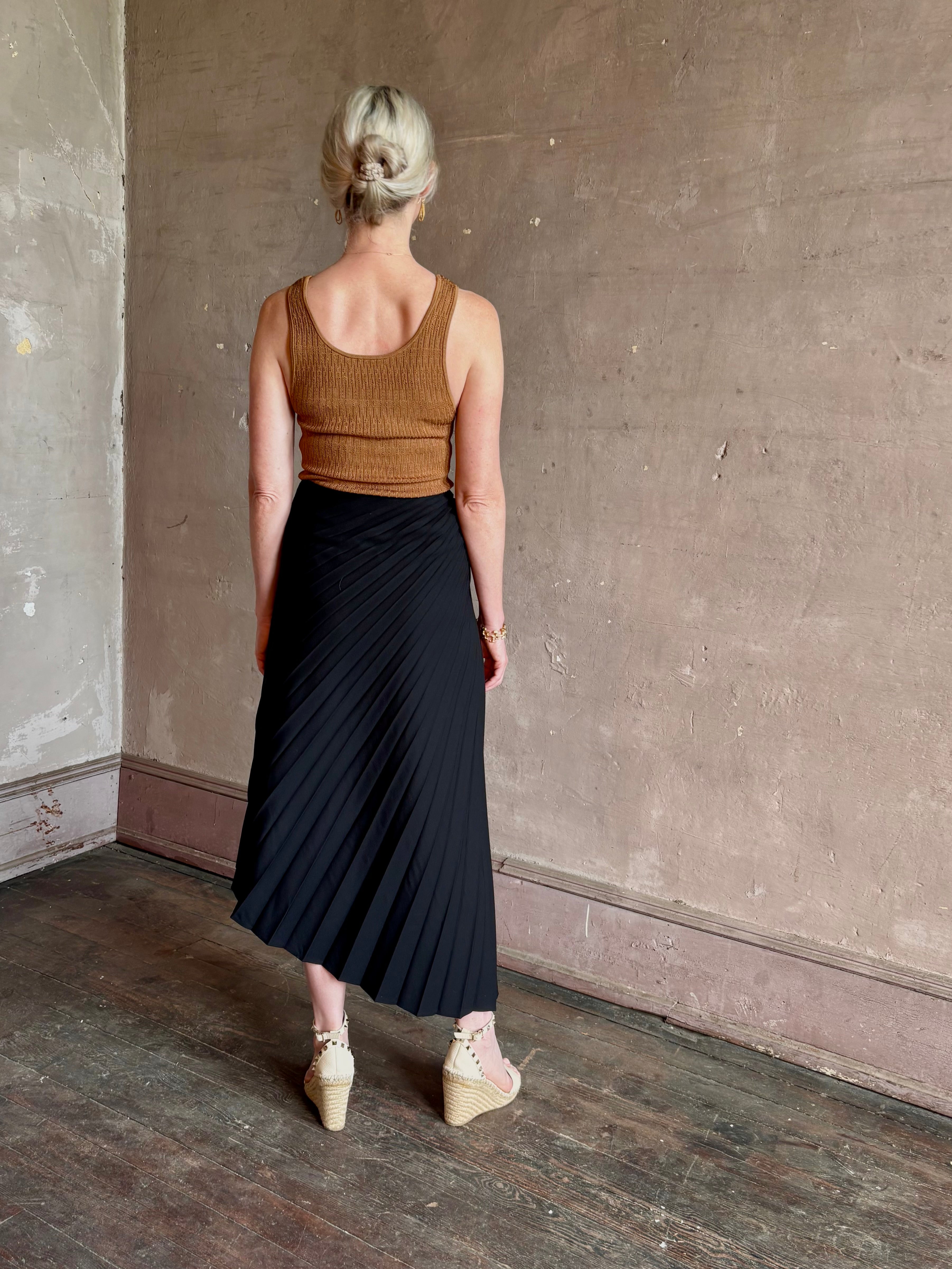 Mature woman wearing ALC Tracy skirt in black wool with asymetrical hemline and pleating