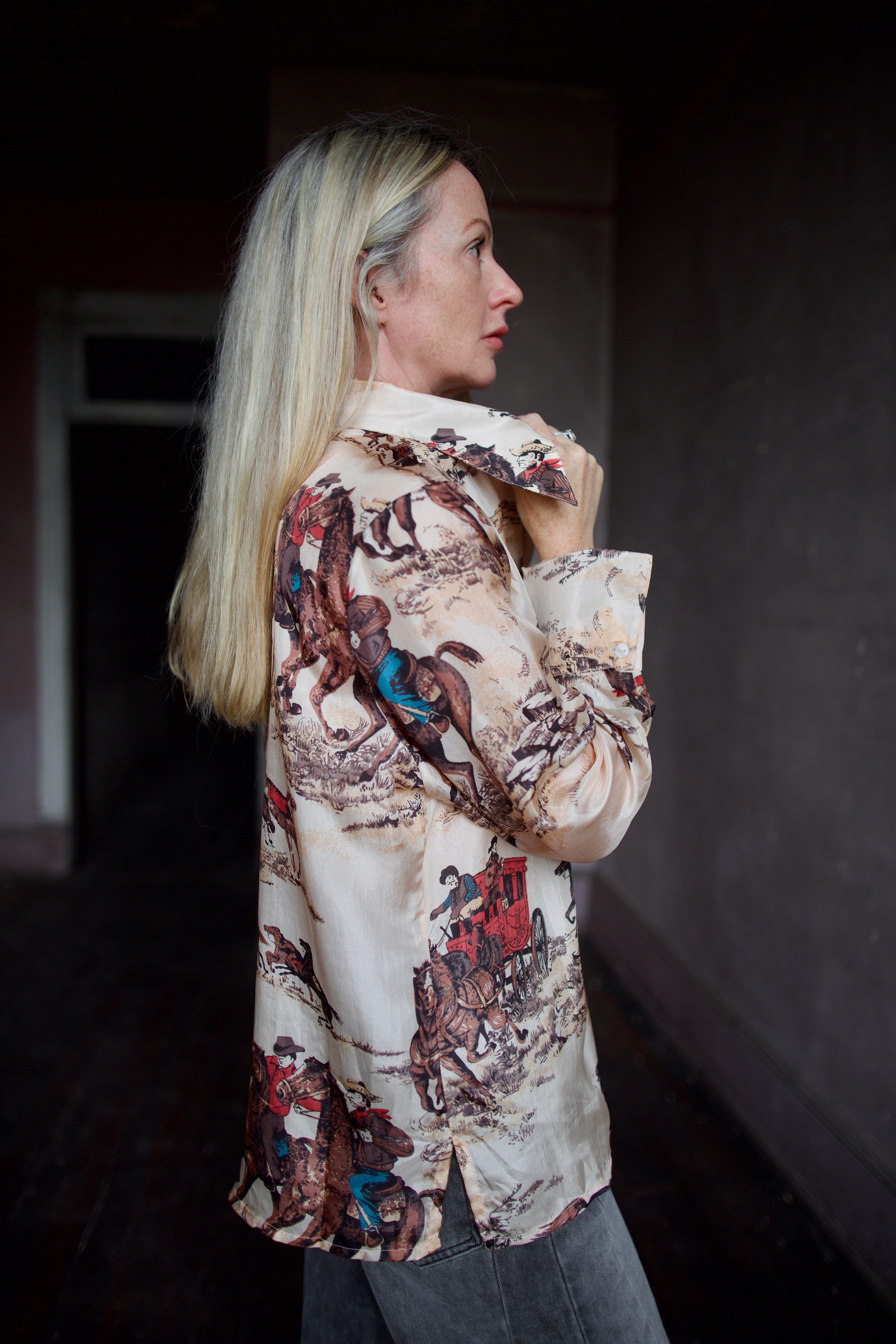 Model wearing a hand woven western Alix of Bohemia blouse with Veronica Beard grey barrel jeans 