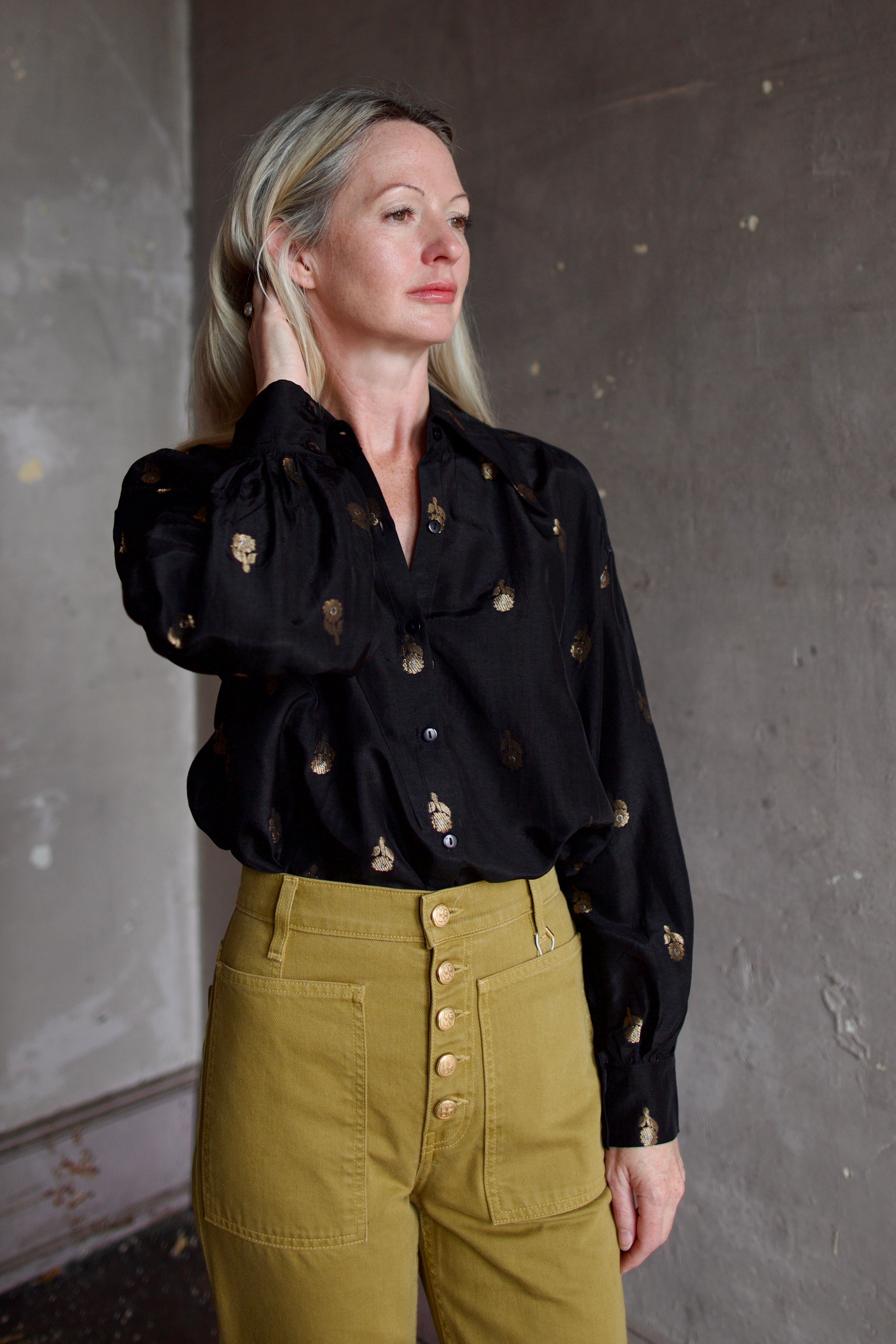 Model wearing Alix of Bohemia Emery Shadow Shirt. Black shirt has bamboo construction and subtle gold metallic accents.