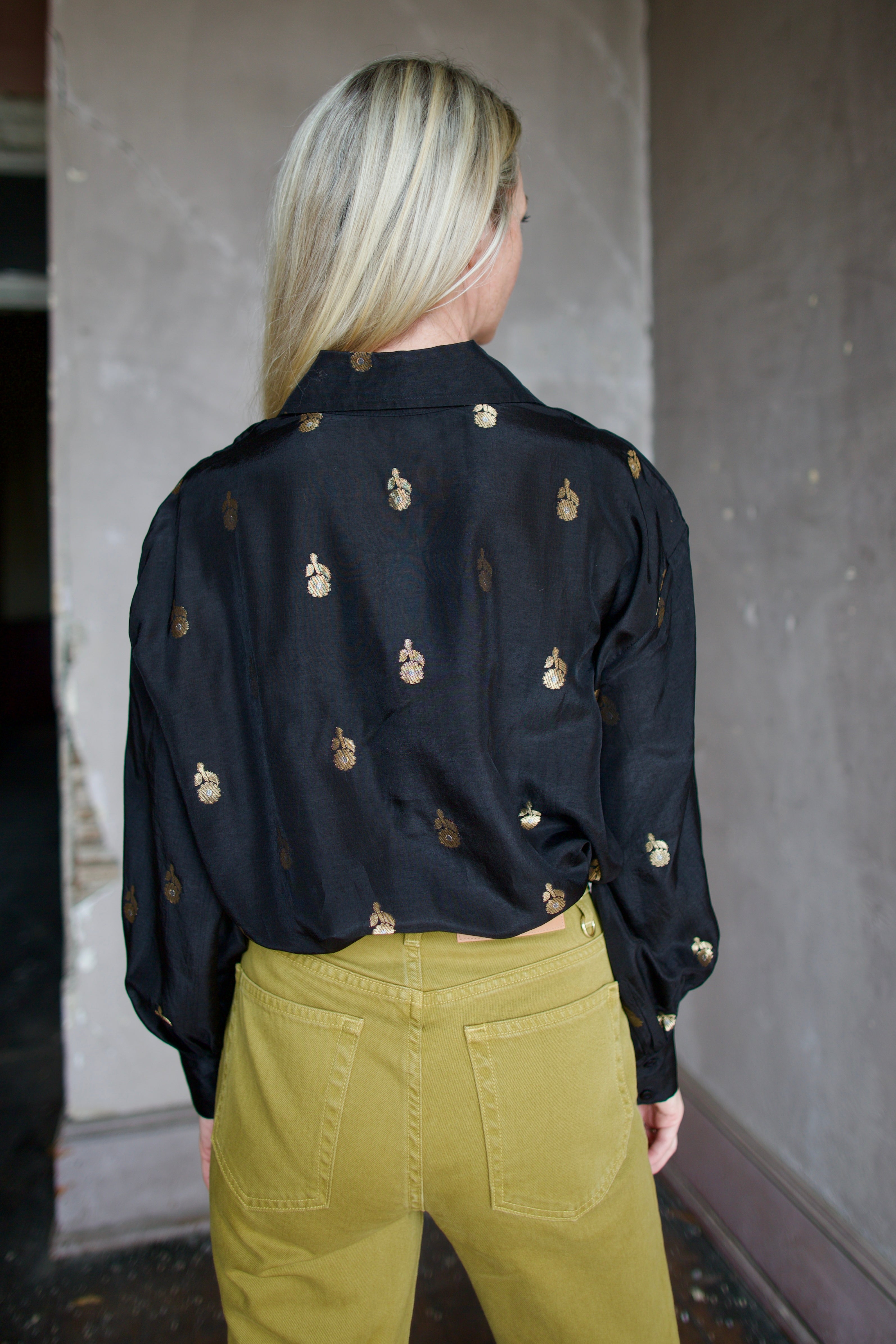 Model wearing Alix of Bohemia Emery Shadow Shirt. Black shirt has bamboo construction and subtle gold metallic accents.