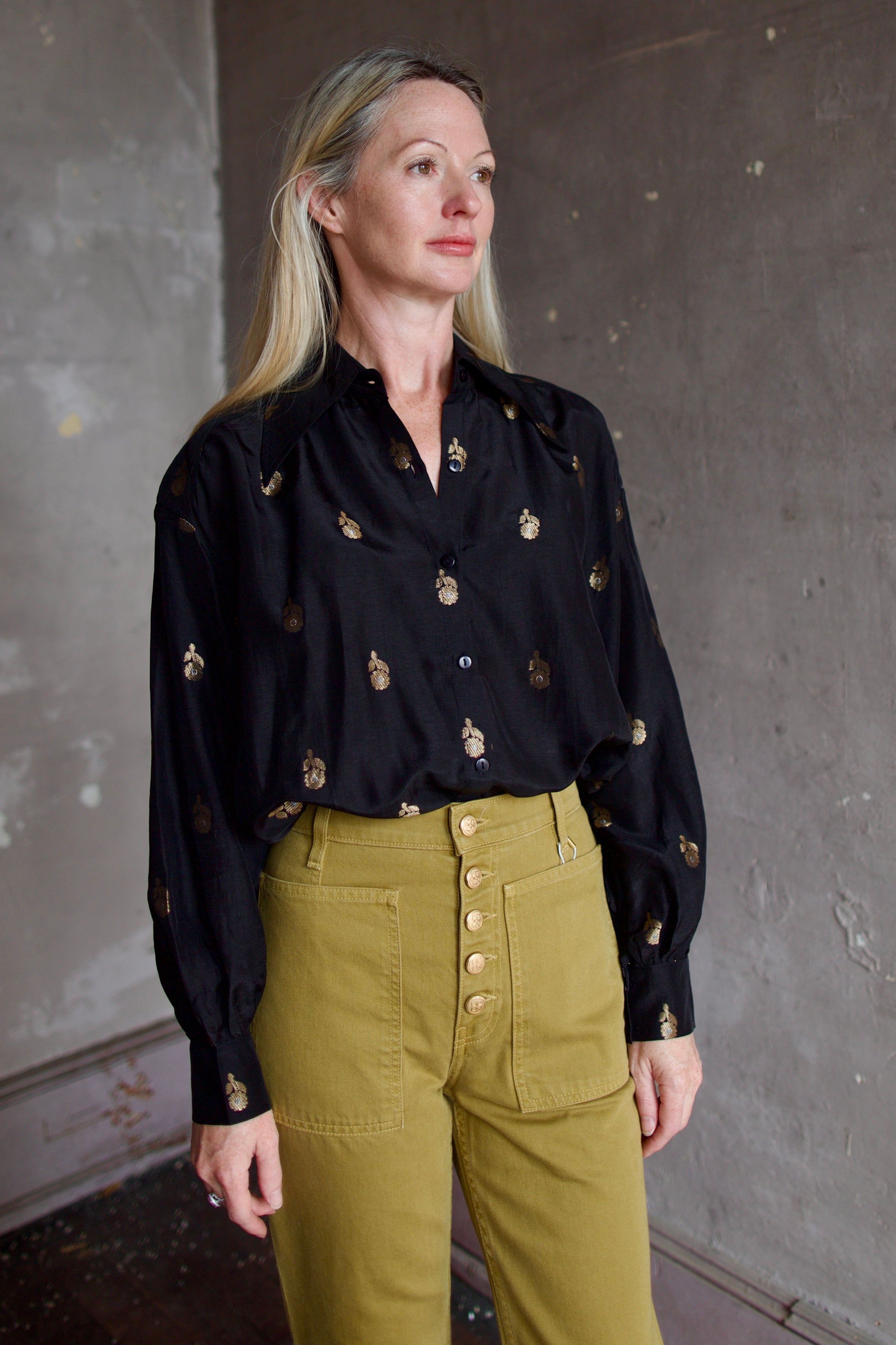 Model wearing Alix of Bohemia Emery Shadow Shirt. Black shirt has bamboo construction and subtle gold metallic accents.