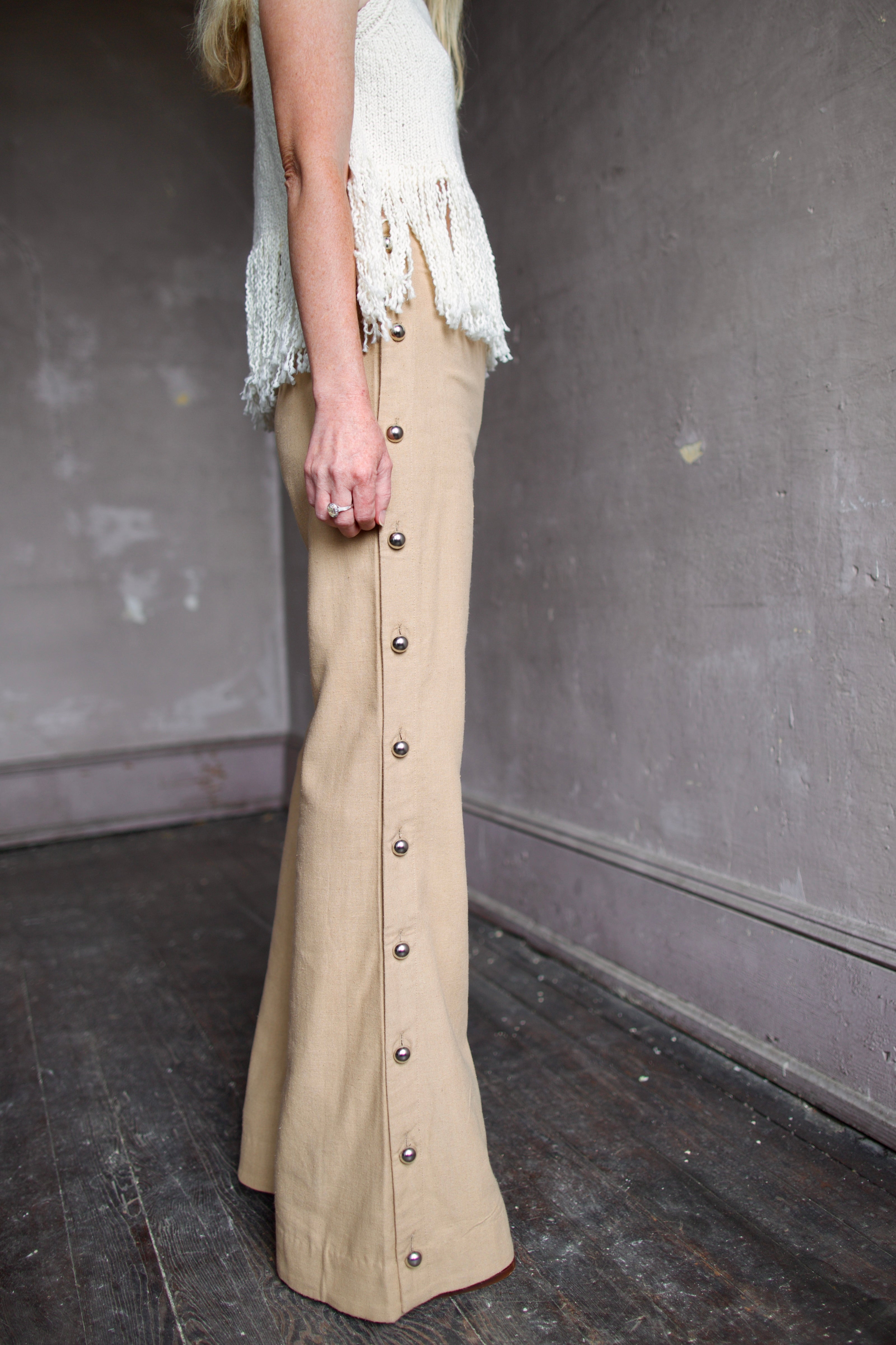 Model wearing neutral silk Alix of Bohemia pants with operable silver button details