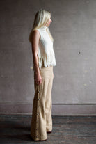 Mature woman wearing beige 100% raw silk Alix of Bohemia tailored trouser operable silver side buttons straight leg 