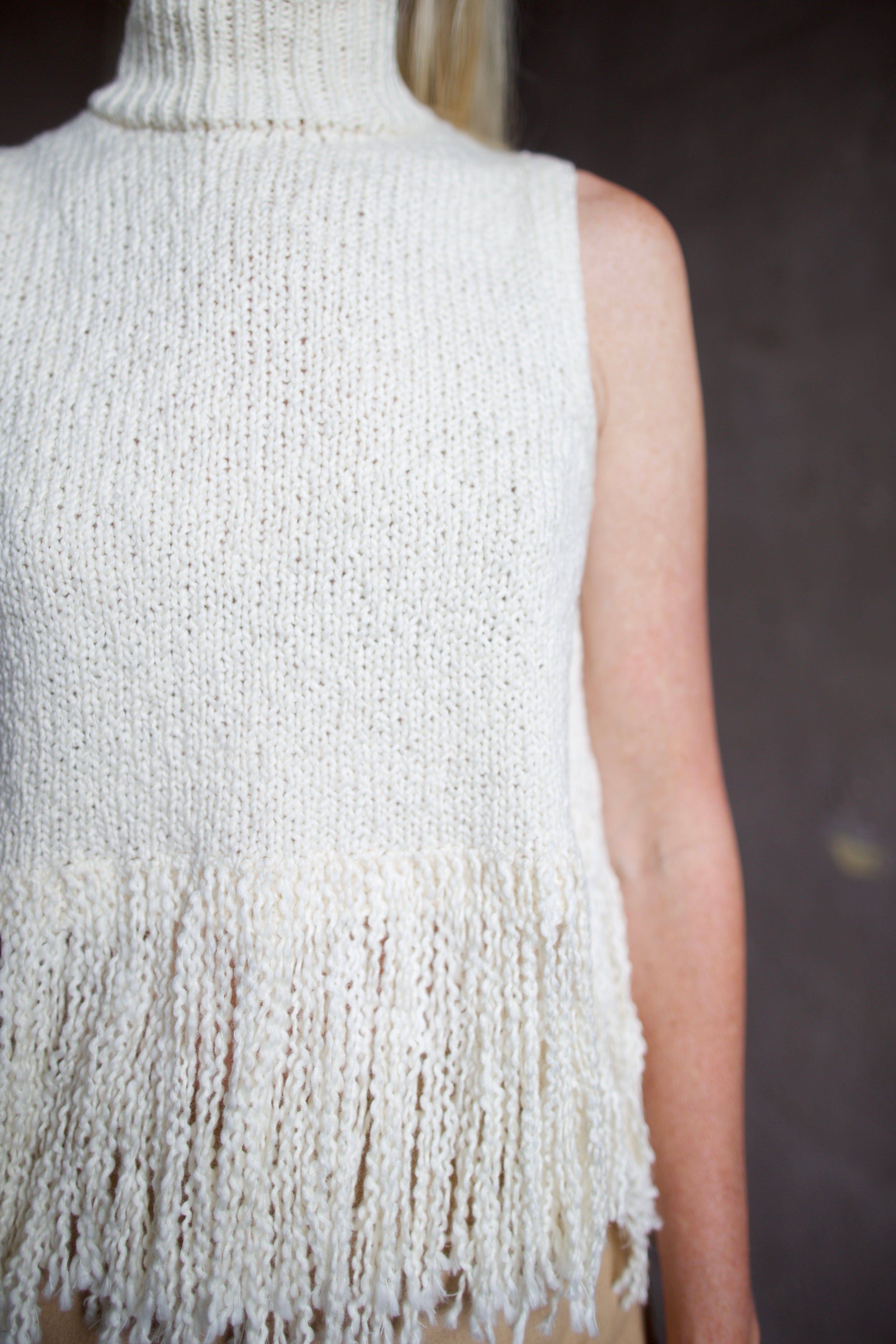 Back of an Alix of Bohemia cream sleeveless cotton sweater with fringe trimmed top