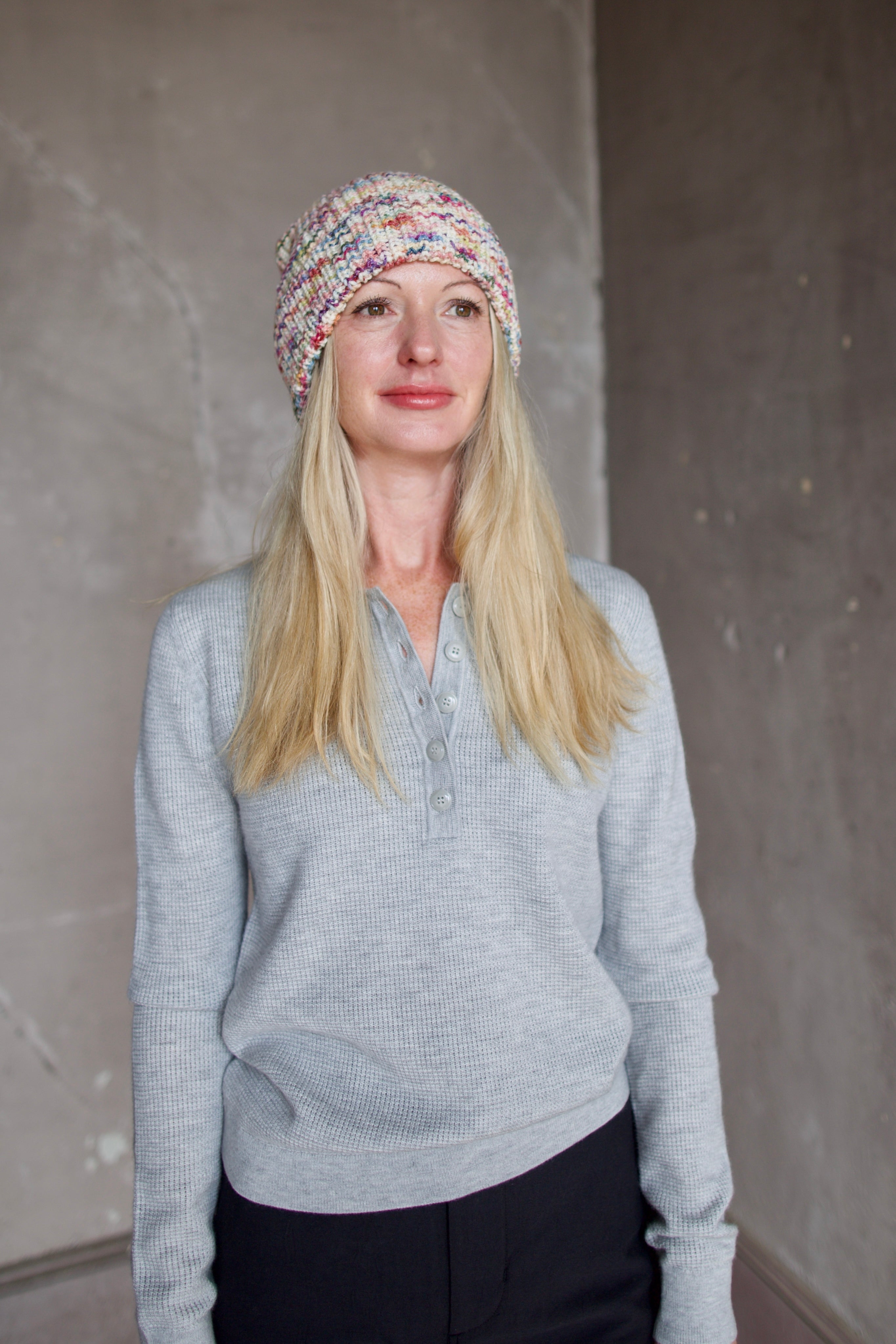 Model wearing Alix of Bohemia Yara Aurora Beanie. Knitted beanie is multicolored with cuff detail.  