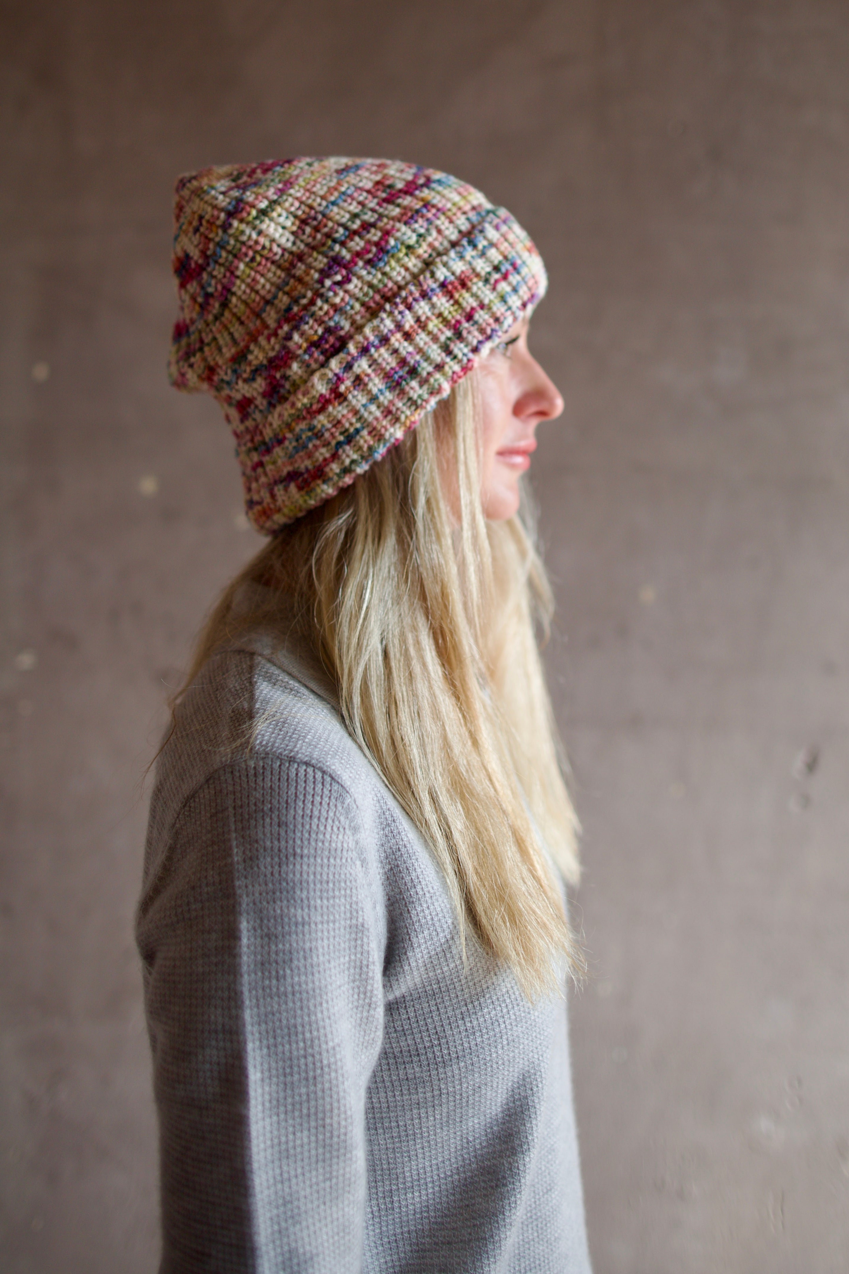 Model wearing Alix of Bohemia Yara Aurora Beanie. Knitted beanie is multicolored with cuff detail.  
